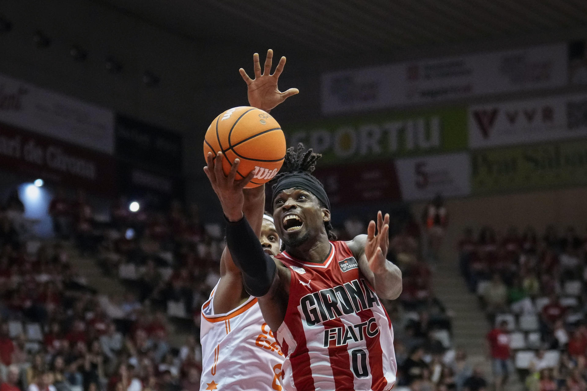 El escolta nigeriano del Girona Ike Iroegbu (d) intenta superar al escolta dominicano del Valencia Basket Jean Montero durante el partido de la Liga Endesa de baloncesto que se disputó en el pabellón de Fontajau de Girona. EFE/David Borrat