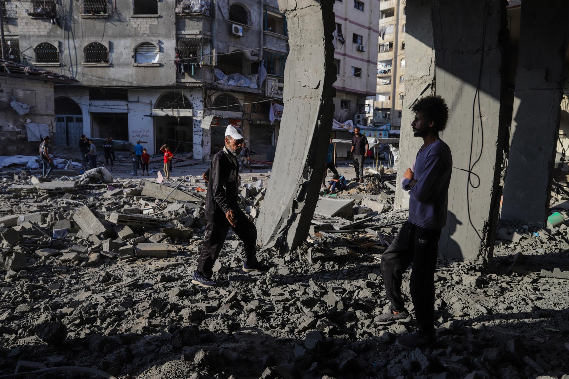Palestinos inspeccionan un edificio destruido tras un ataque aéreo israelí en la calle Al Nasr de Ciudad de Gaza, al norte de la Franja de Gaza. EFE/ Mohammed Saber