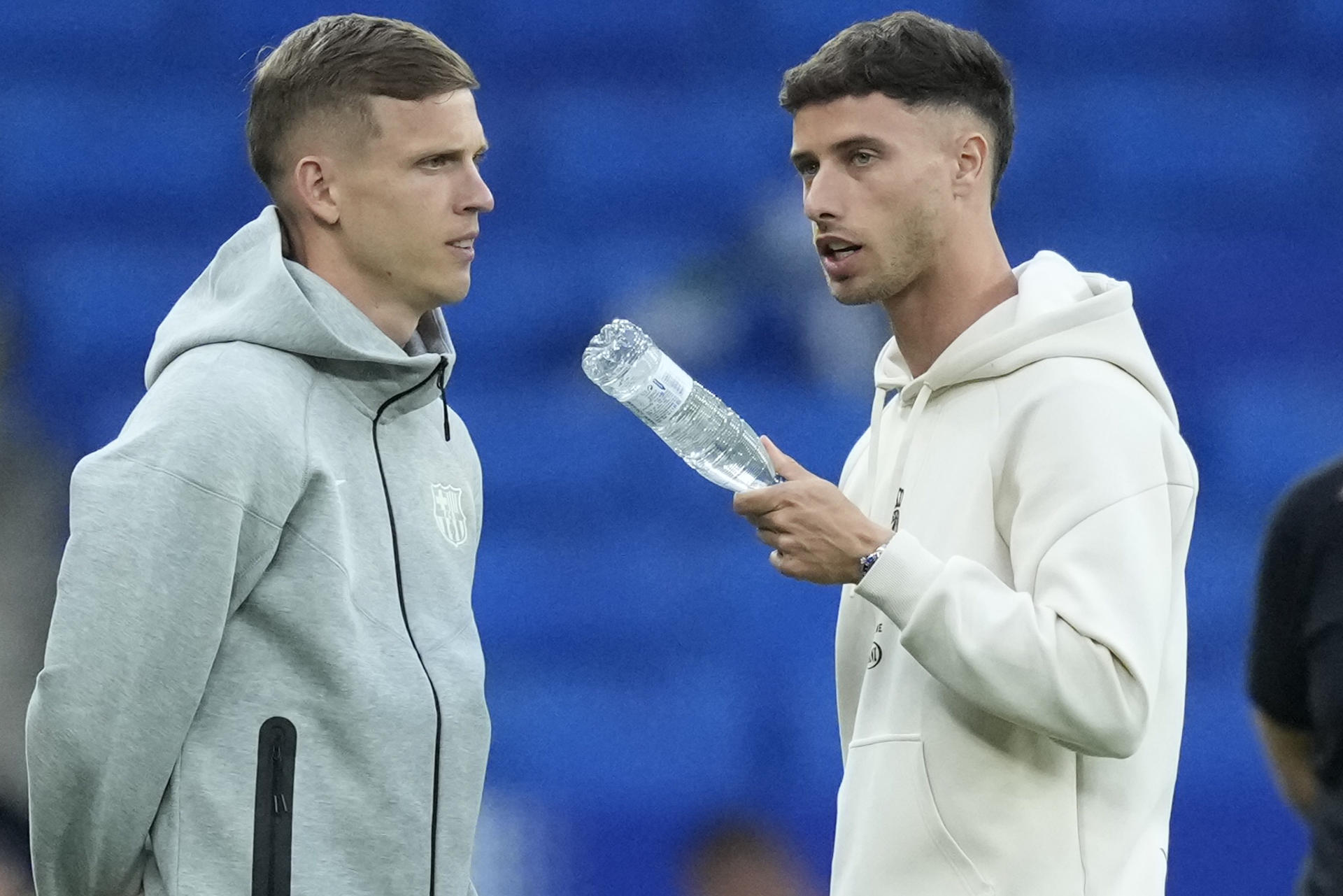El delantero del Barcelona Dani Olmo (i) conversa con el delantero del Espanyol Javi Puado en la inspección de campo previa al partido de LaLiga entre el Espanyol y el Barcelona, este jueves en el RCDE Stadium. EFE/ Enric Fontcuberta