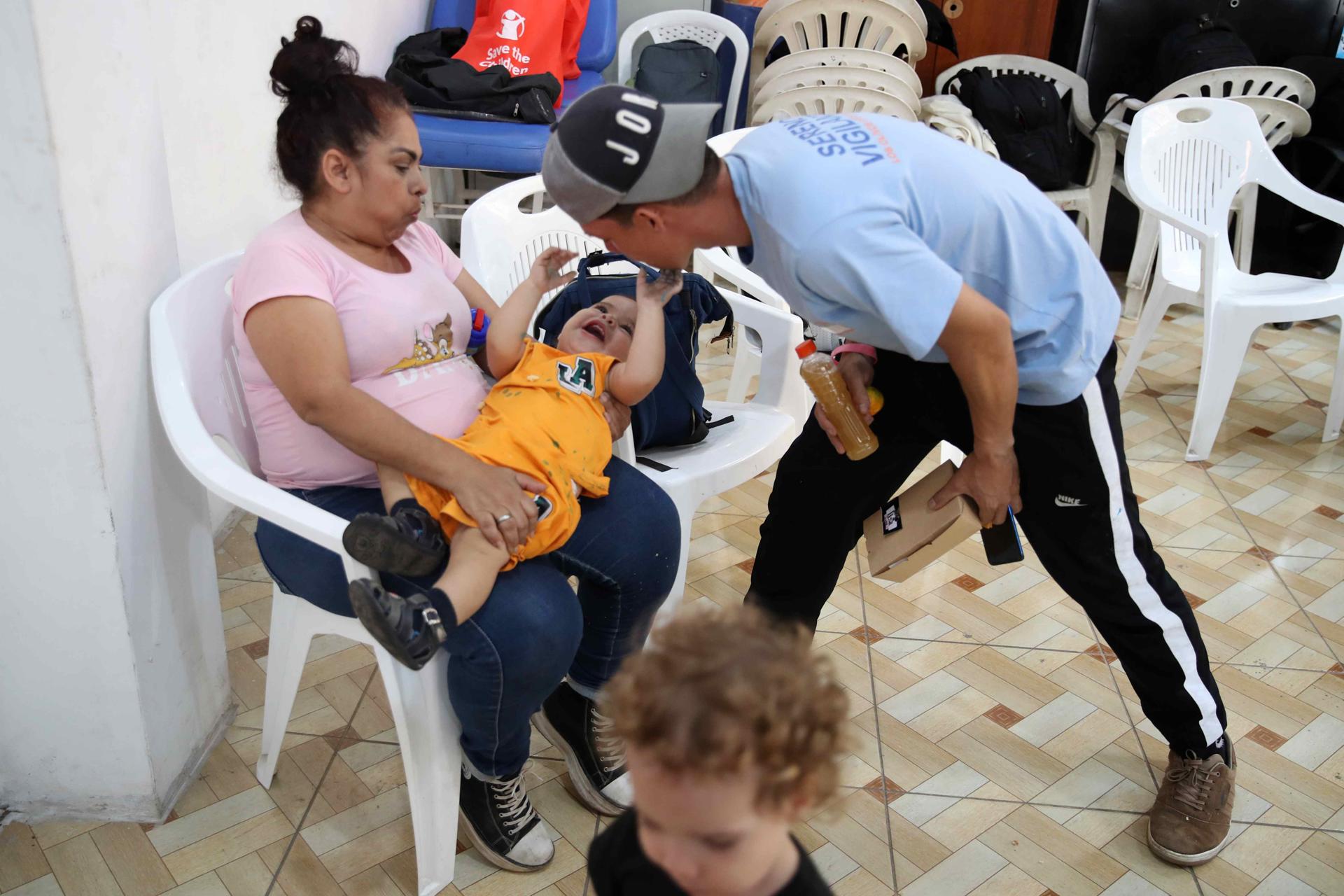 Fotografía del 28 de abril de 2025 de dos personas jugando con un niño en un centro parroquial en Lima (Perú). EFE/ Paolo Aguilar