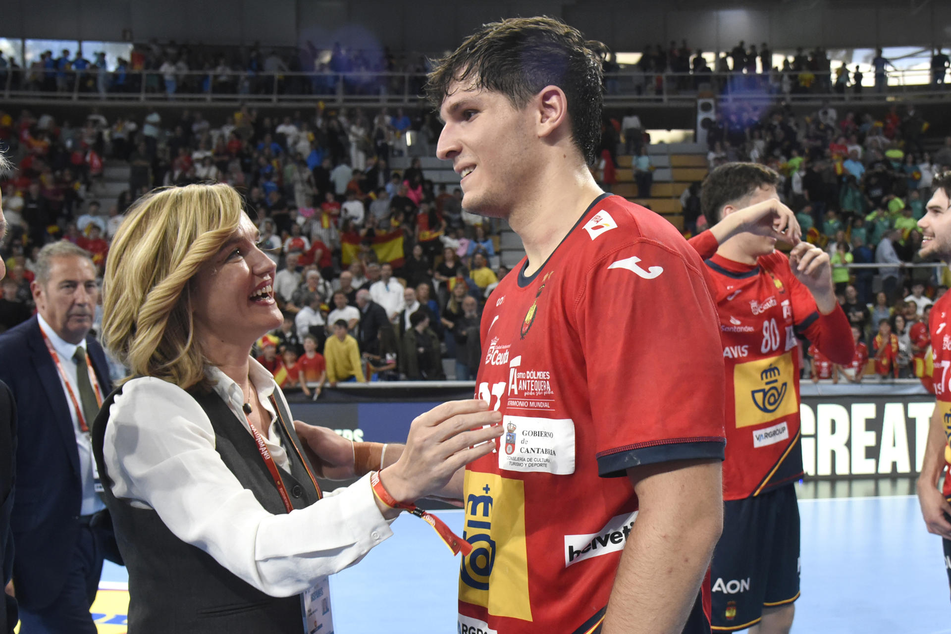 Pilar Alegría, ministra de Educación, felicita a los jugadores de la seleccion española, que celebran su victoria tras el partido de la selección Española de balonmano contra la selección de Letonia, este domingo en Huesca.-EFE/ Javier Blasco