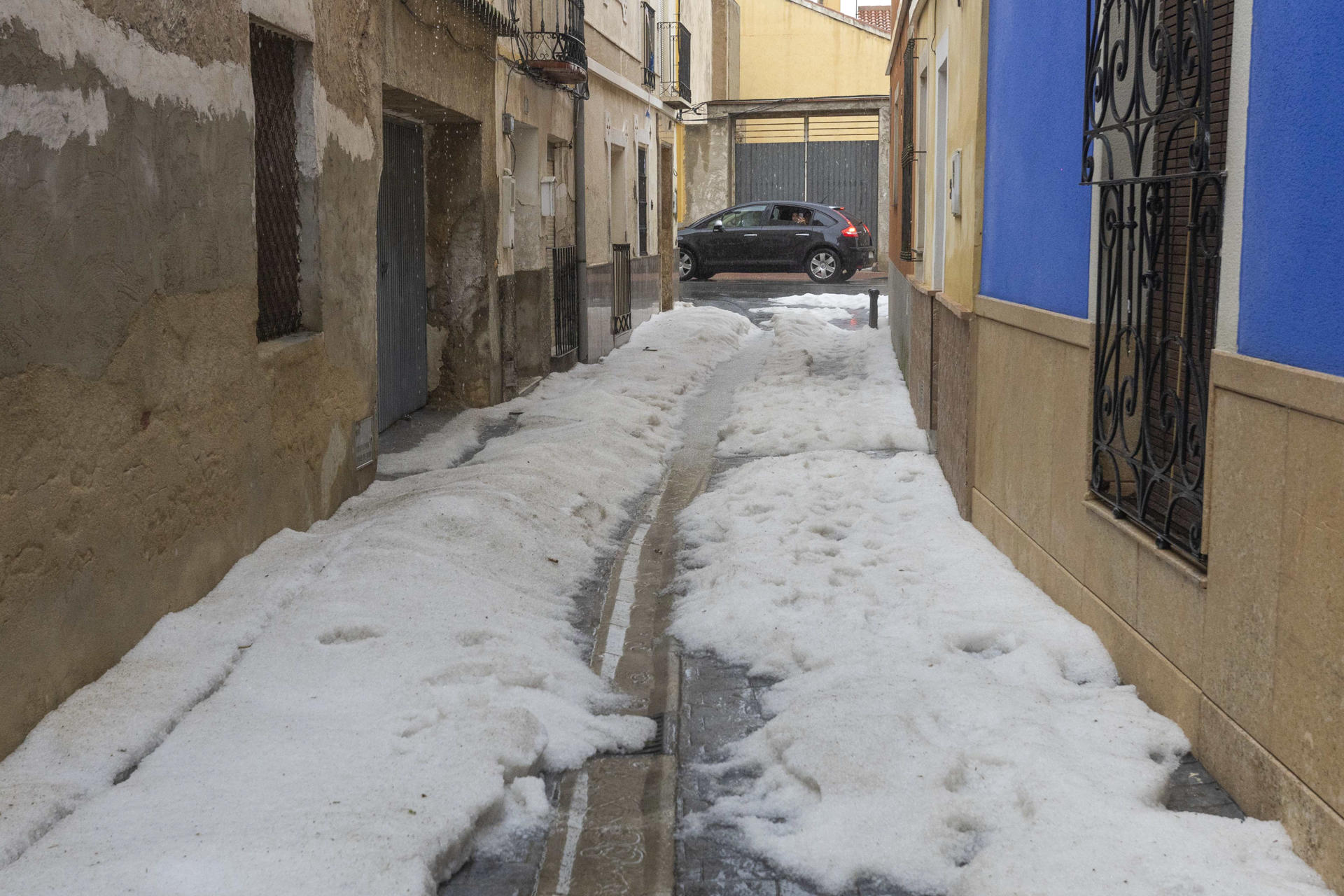 Granizo acumulado en una calle de de La Puebla de Mula, tras la tormenta de granizado que ha caído en los municipios de Mula, Bullas, Calasparra y Cehegín. La autovía del noroeste se ha cortado un tiempo un carril por sentido hasta que el granizo acumulado ha sido retirado con quitanieves autonómicos. EFE/Marcial Guillén