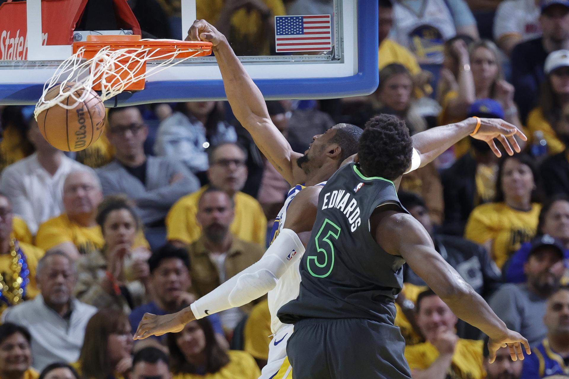 Jonathan Kuminga (i) de los Golden State Warriors anota ante la marca de Anthony Edwards (d) de los Minnesota Timberwolves. EFE/JOHN G. MABANGLO