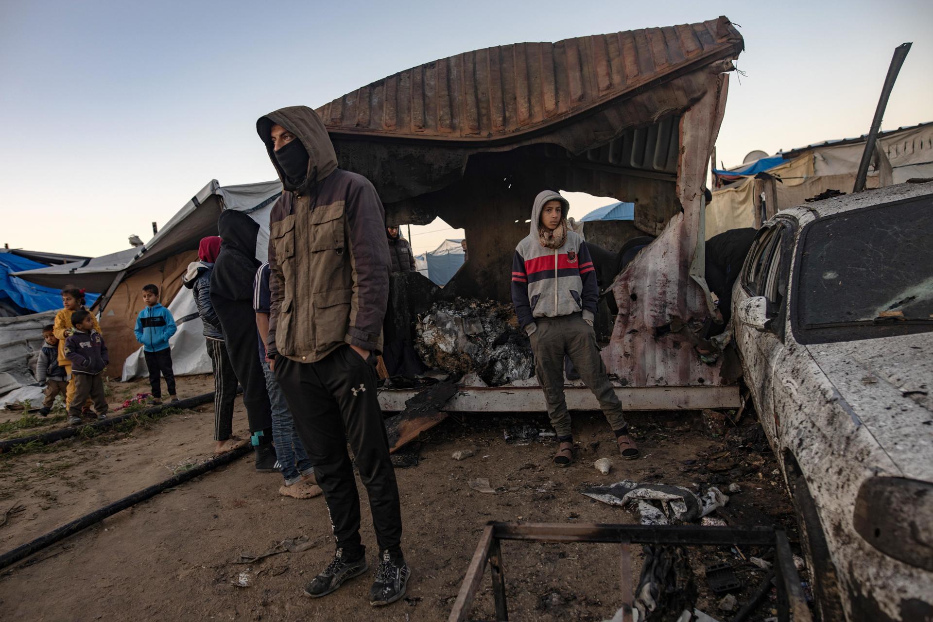 Foto de archivo de unos palestinos que inspeccionan los daños después de que un ataque aéreo israelí alcanzara un campamento de desplazados internos en el área de Mawasi, al oeste de Jan Yunis, en el sur de la Franja de Gaza. EFE/EPA/HAITHAM IMAD