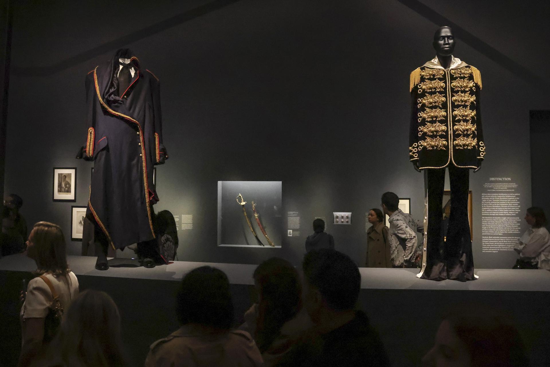 Personas observan las prendas en exhibición durante la presentación a la prensa de la exposición del Instituto del Vestuario del Met titulada ‘Superfine: Tailoring Black Style’, en el Museo Metropolitano de Arte de Nueva York, Estados Unidos. EFE/EPA/SARAH YENESEL