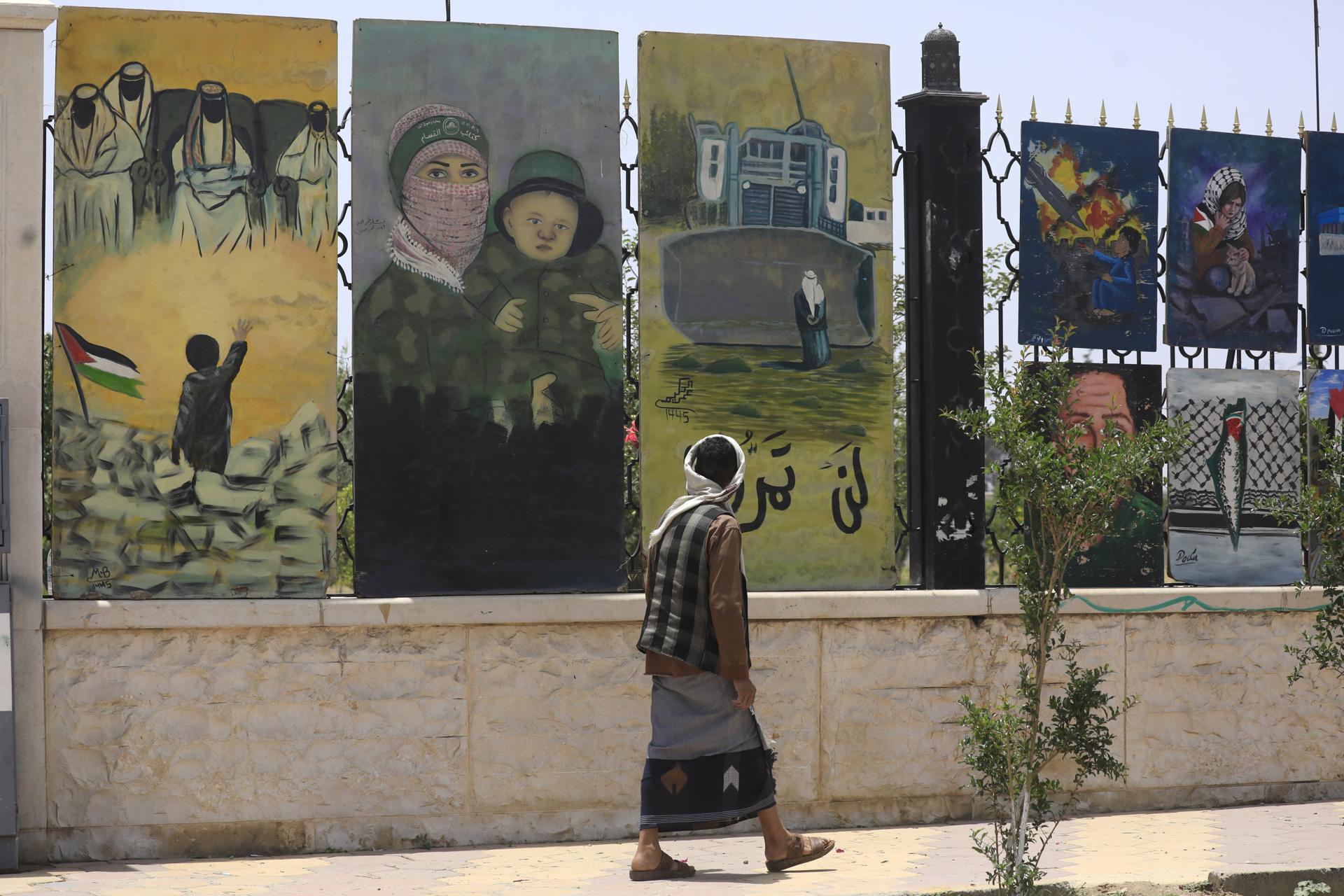 Una persona pasa junto a una valla adornada con obras de arte pro-palestinas en Saná, Yemen, 11 de mayo de 2025. EFE/EPA/YAHYA ARHAB