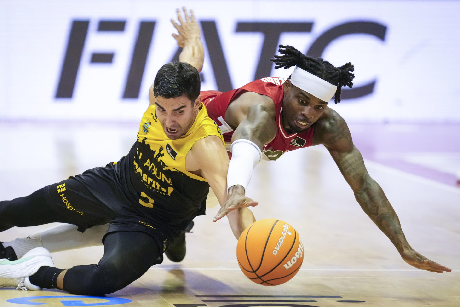 Los jugadores de Laguna Tenerife Jaime Fernández (izda) e Ike Iroegbu del Basquet Girona luchan por un balón, durante el partido de la Liga Endesa de baloncesto que ambos equipos disputan en el pabellón de Fontajau de Girona. EFE/David Borrat