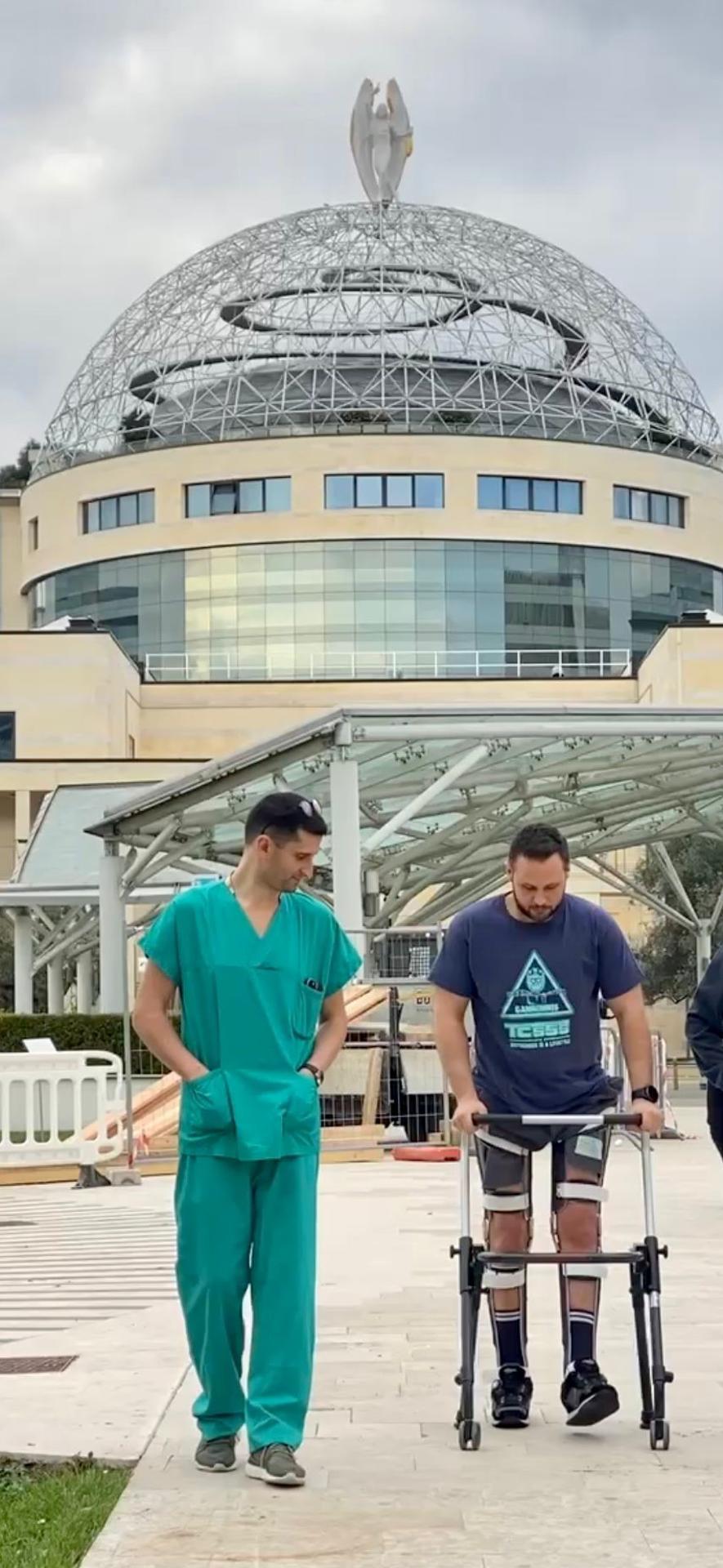 El paciente camina a la puerta del hospital junto al doctor Luigi Albano. Crédito: Imagen cedida por IRCCS Ospedale San Raffaele /SOLO USO EDITORIAL.