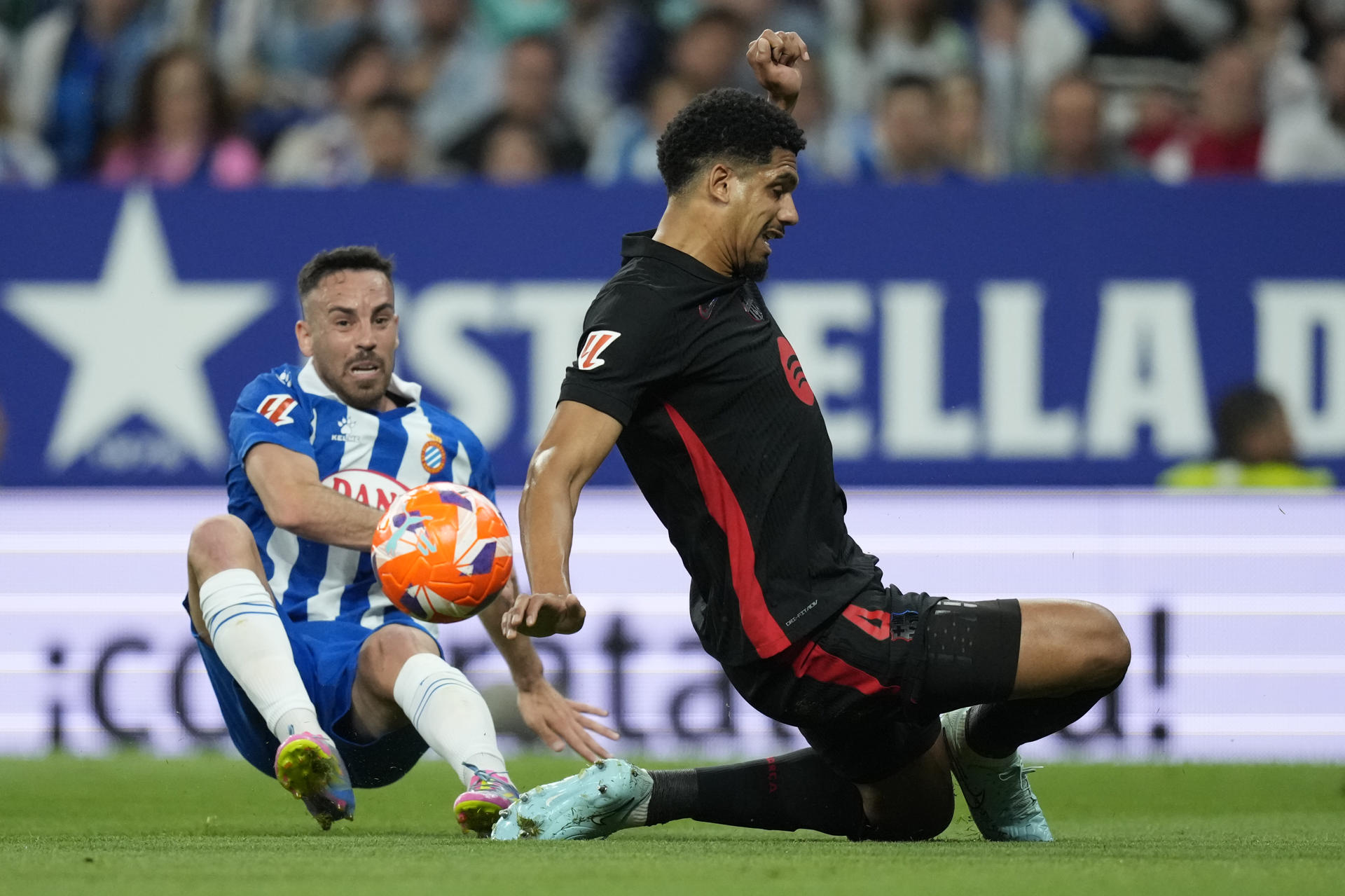 El centrocampista del Espanyol, Edu Expósito (i), disputa el balón ante el defensa uruguayo del FC Barcelona, Ronald Araujo, durante el encuentro correspondiente a la jornada 36 de Laliga EA Sports que disputaron RCD Espanyol y FC Barcelona en el RCDE Stadium, en Cornellá de Llobregat, Barcelona. EFE / Enric Fontcuberta.