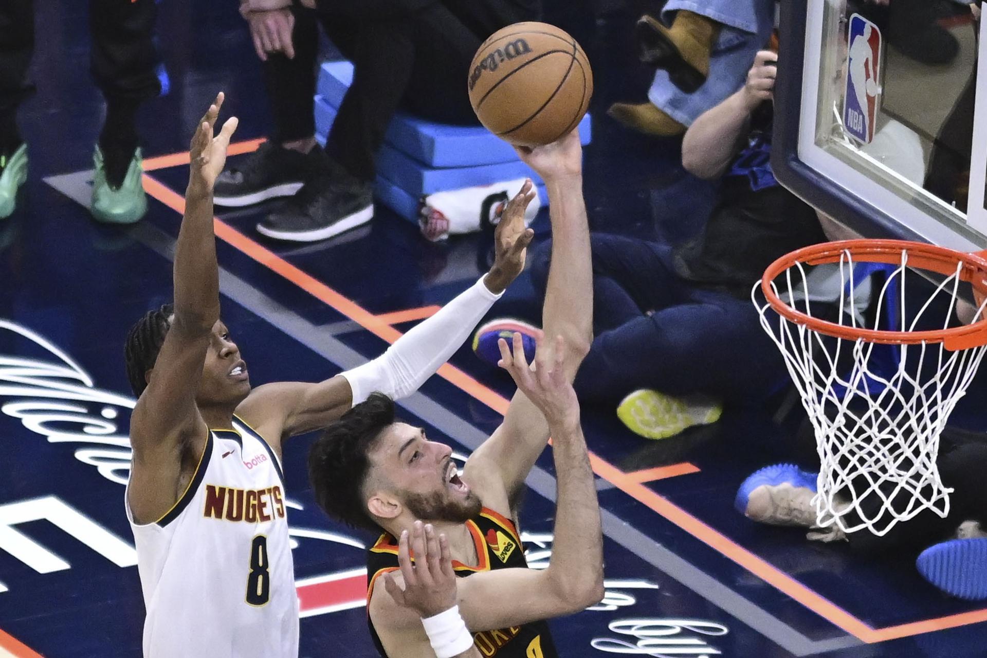 El alero de los Oklahoma City Thunder, Chet Holmgren (d), conduce hacia la canasta por encima del alero de los Nuggets, Peyton Watson (i), durante el primer partido de las semifinales de la Conferencia Oeste que ganaron los de Denver por 119-121 y les deja con ventaja de 0-1 en la serie. EFE/EPA/GERALD LEONG