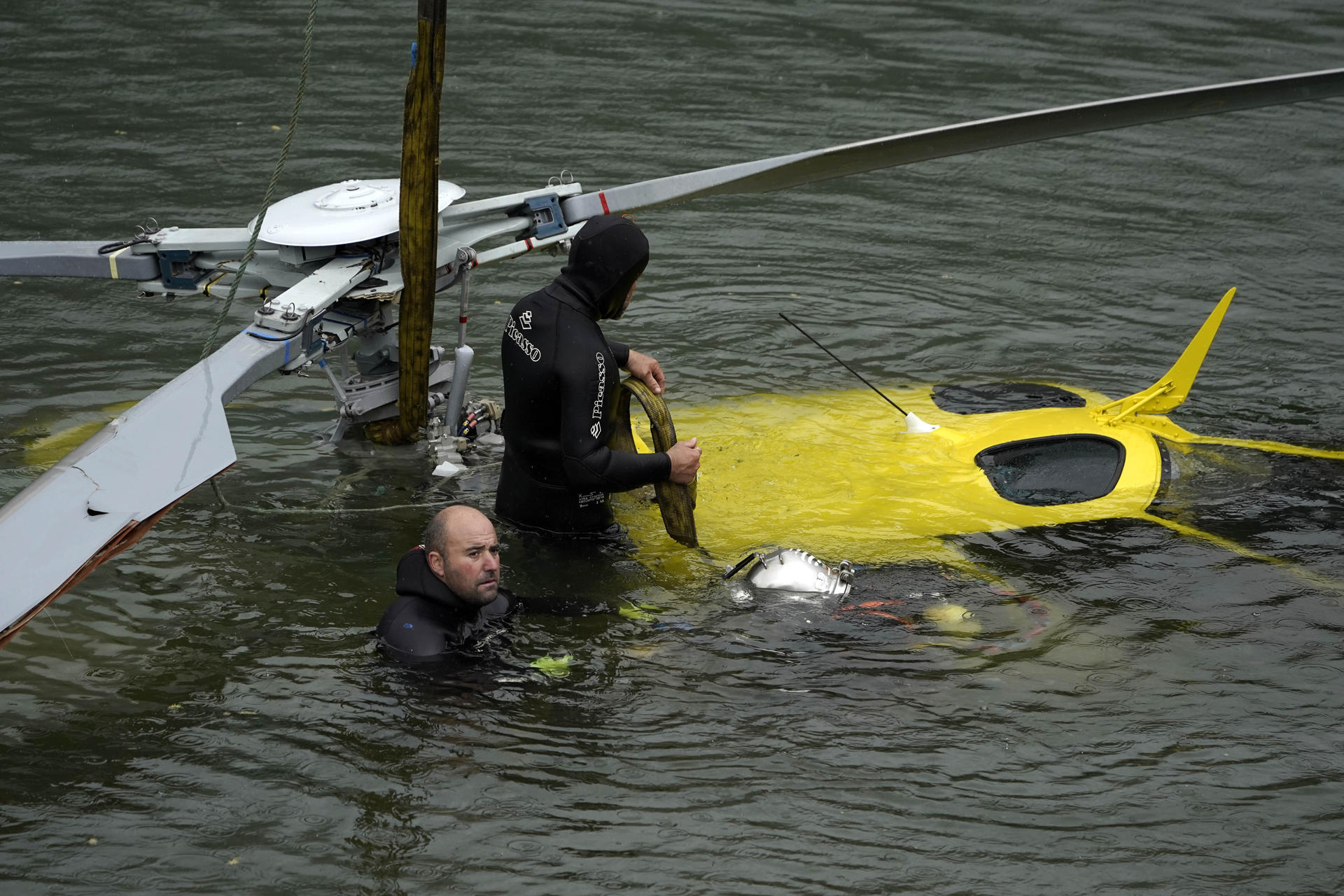 Un equipo de buzos se ha encargado de reflotar este domingo el helicóptero de Bomberos de Asturias que el viernes se precipitó al embalse de Tanes al tropezar con un tendido eléctrico la estructura que llevaba colgada para sacar agua destinada a las tareas de extinción de un incendio forestal cercano. El helicóptero se encontraba boca abajo a diez metros de profundidad en la cabecera de este embalse, destinado al abastecimiento de agua potable a cientos de miles de personas del área central de Asturias. EFE/ Paco Paredes