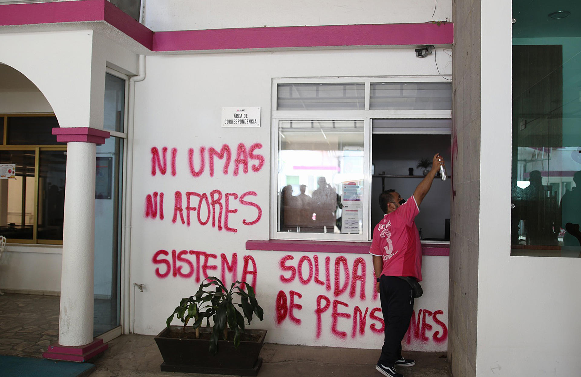 Una persona integrante de la Coordinadora Estatal de Trabajadores de la Educación en Guerrero (CETEG), vandaliza este lunes las instalaciones del Instituto Nacional Electoral en la ciudad de Chilpancingo (México). EFE/ José Luis de la Cruz