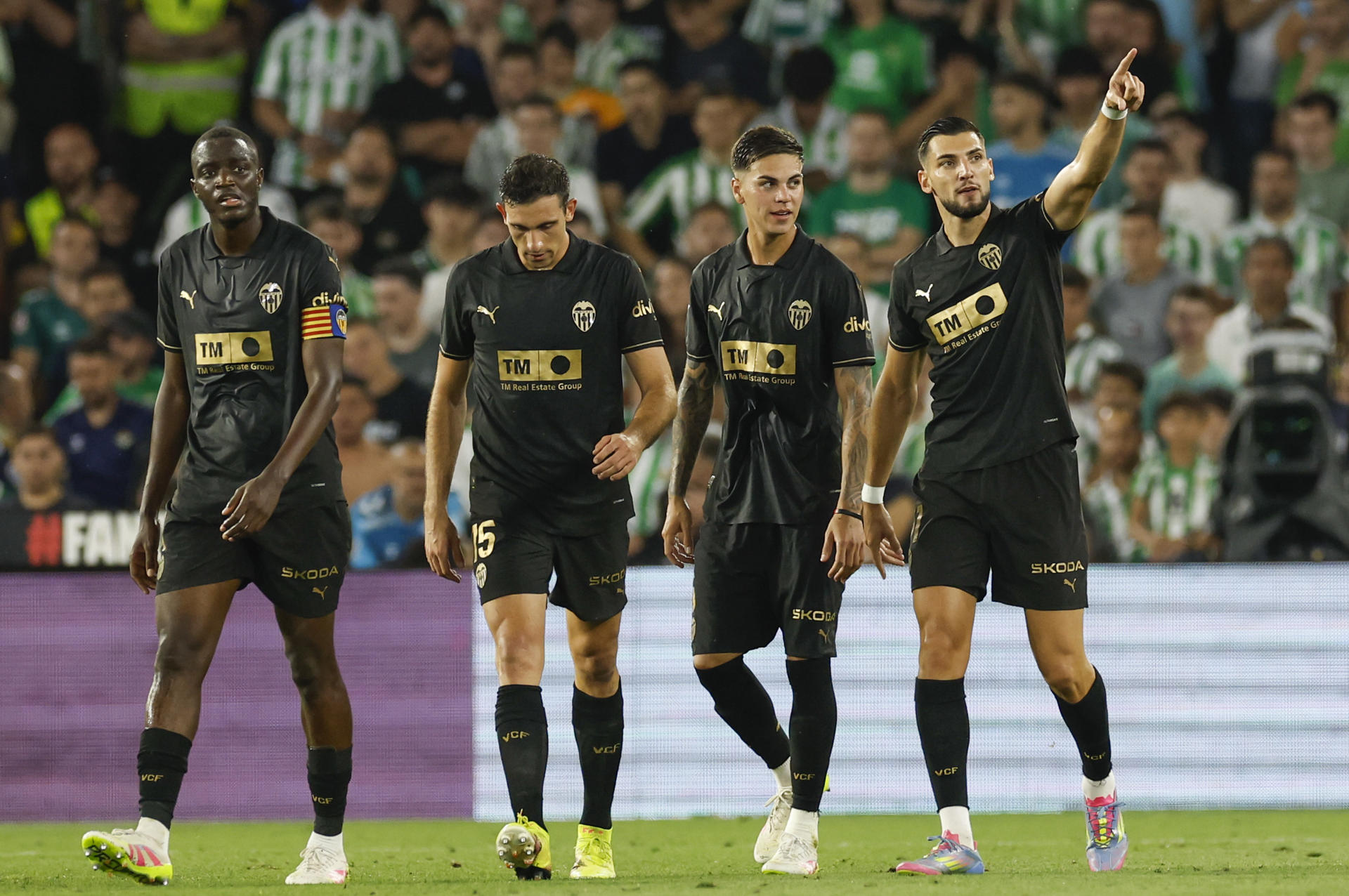El delantero del Valencia Rafa Mir (d) celebra junto a sus compañeros tras marcar ante el Betis, durante el partido de la última jornada de LaLiga de fútbol que Real Betis y Valencia CF disputan este viernes en el estadio Benito Villamarín, en Sevilla. EFE/Julio Muñoz