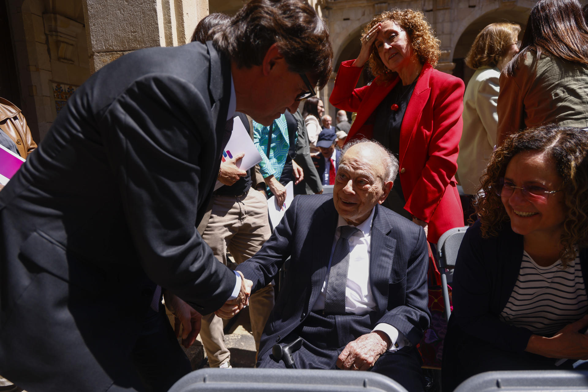 El presidente de la Generalitat, Salvador Illa (I), saluda al expresidente catalán Jordi Pujol durante el acto de la firma del acuerdo del Pacto Nacional por la Lengua que se ha formalizado este martes, tras el consenso alcanzado por Govern, ERC, Comuns, sindicatos, patronales y entidades, aunque sin el apoyo de Junts y la CUP. EFE/Quique García
