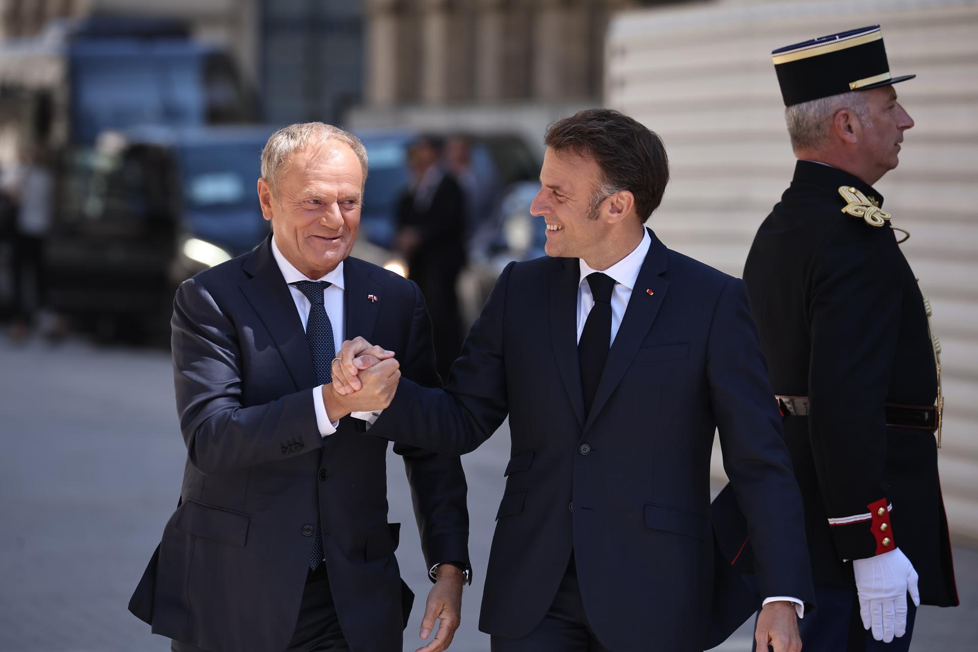 El presidente francés Emmanuel Macron (D) recibe al primer ministro polaco Donald Tusk (I) a su llegada a la plaza Stanislas de Nancy, en el este de Francia, el 9 de mayo de 2025. El presidente francés Macron y el primer ministro polaco Tusk se reúnen en Nancy en el marco de una cumbre para firmar un tratado de amistad y cooperación reforzada entre Francia y Polonia. (Francia, Polonia) EFE/EPA/CHRISTOPHE PETIT TESSON / POOL