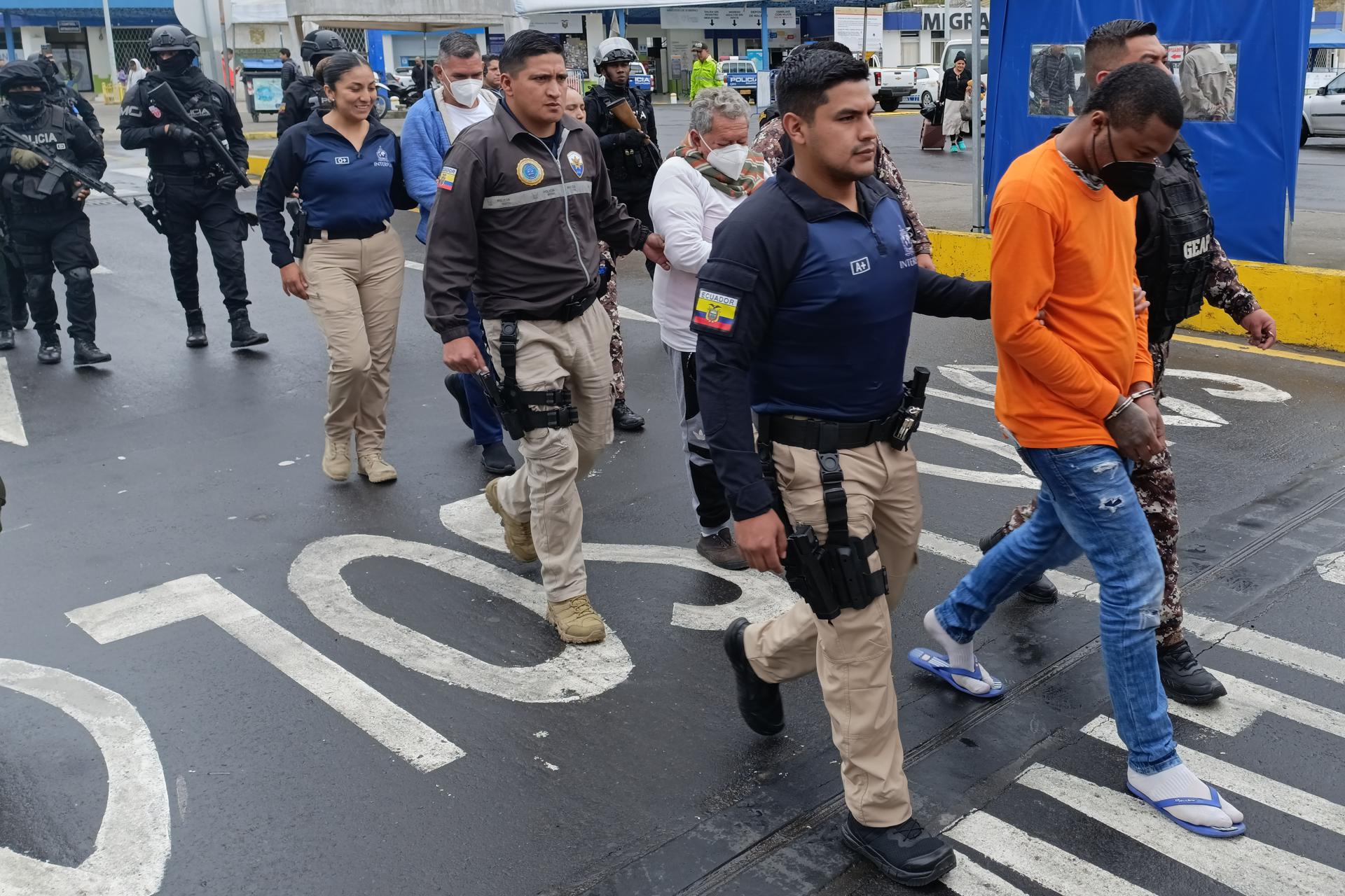 Integrante de la Organización Internacional de Policía Criminal - INTERPOL custodian a colombianos este miércoles, en Rumichaca (Ecuador). EFE/ Xavier Montalvo
