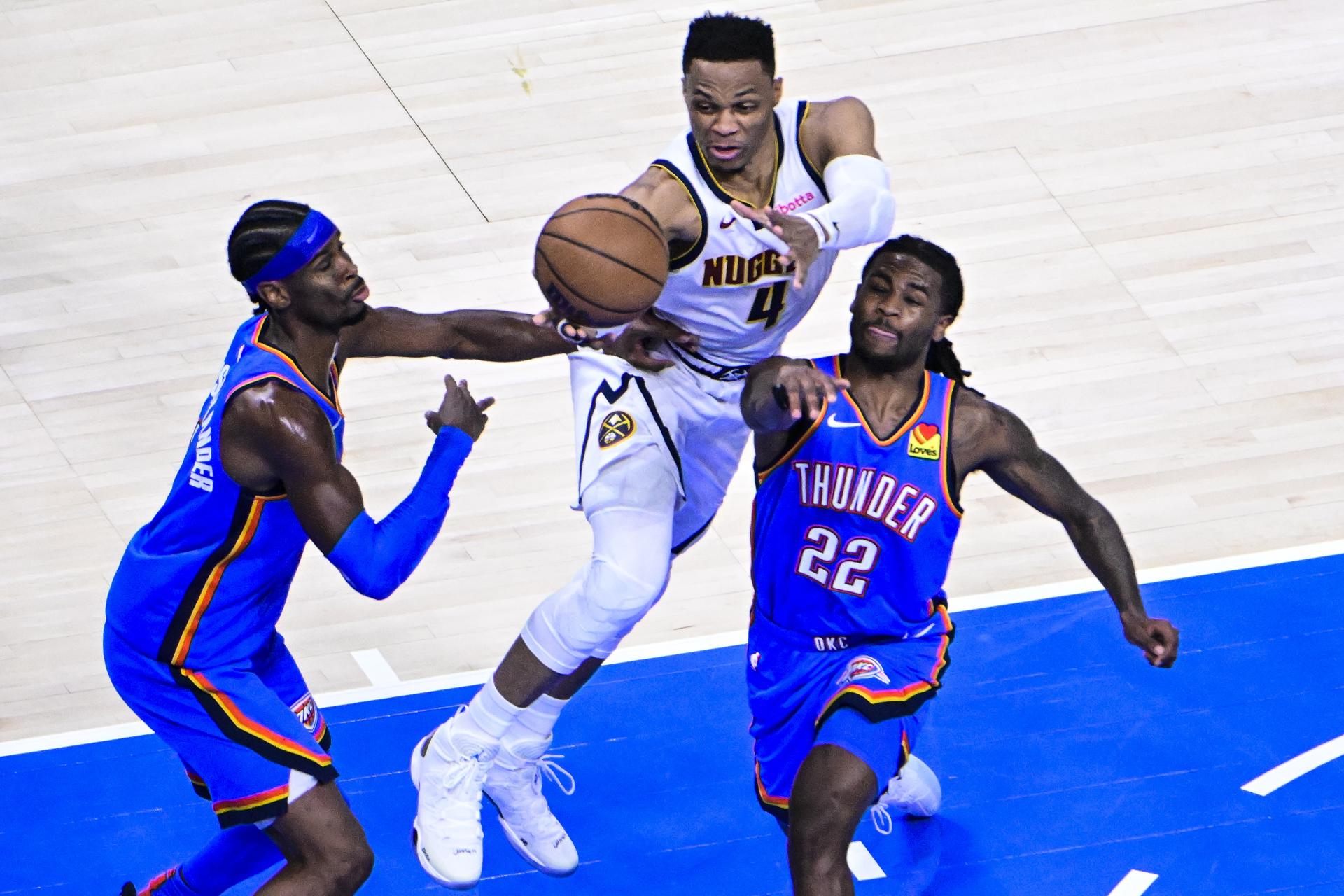El guardia de los Nuggets Russell Westbrook (c) intenta desmarcarse de los jugadores de los Thunder Cason Wallace y Shai Gilgeous-Alexander. EFE/EPA/GERALD LEONG