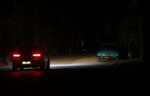 Fotografía de archivo en donde se ve un auto que transita por una calle durante un apagón en Cuba. EFE/ Ernesto Mastrascusa
