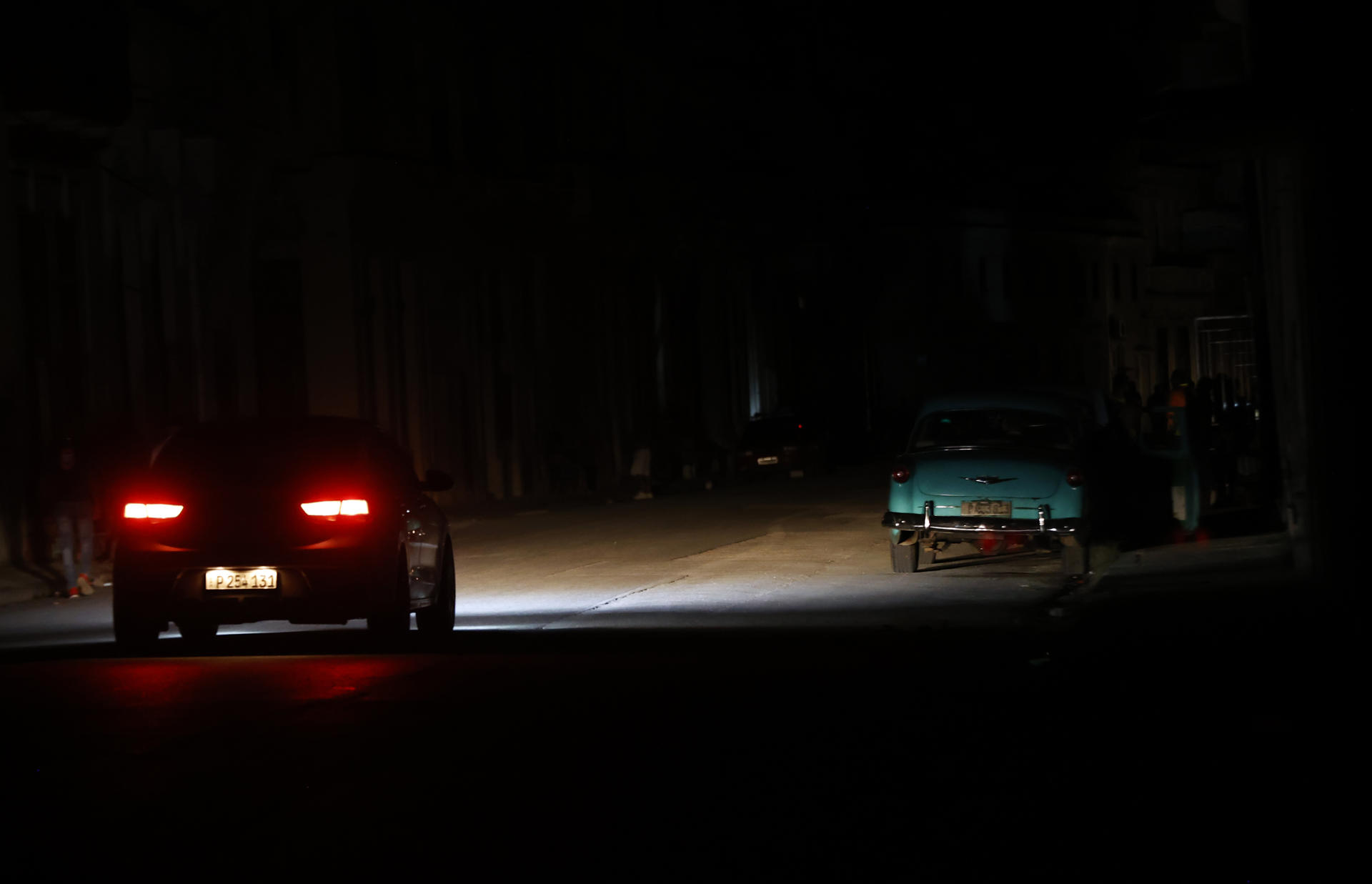 Fotografía de archivo en donde se ve un auto que transita por una calle durante un apagón en Cuba. EFE/ Ernesto Mastrascusa