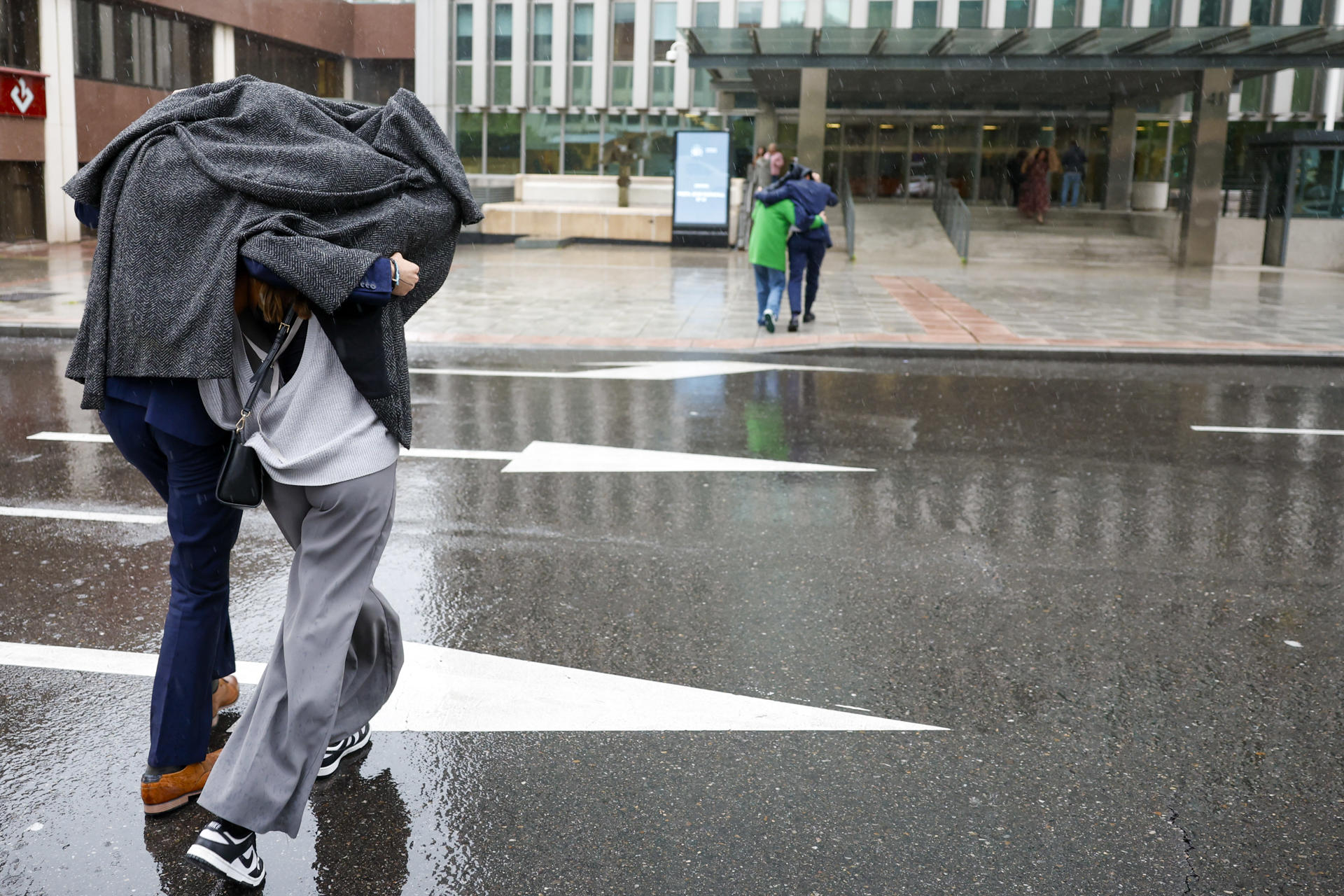Varias personas se protegen de la lluvia caída este lunes en Madrid. EFE/ Mariscal