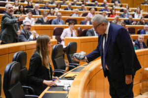 El senador del PP Francisco Bernabé entrega a la vicepresidenta tercera y ministra para la Transición Ecológica, Sara Aagesen, una bolsa llena de estéril minero como protesta y para exigir que se regenere la bahía de Portmán (Murcia), durante el pleno del Senado celebrado este martes. EFE/Borja Sánchez-Trillo