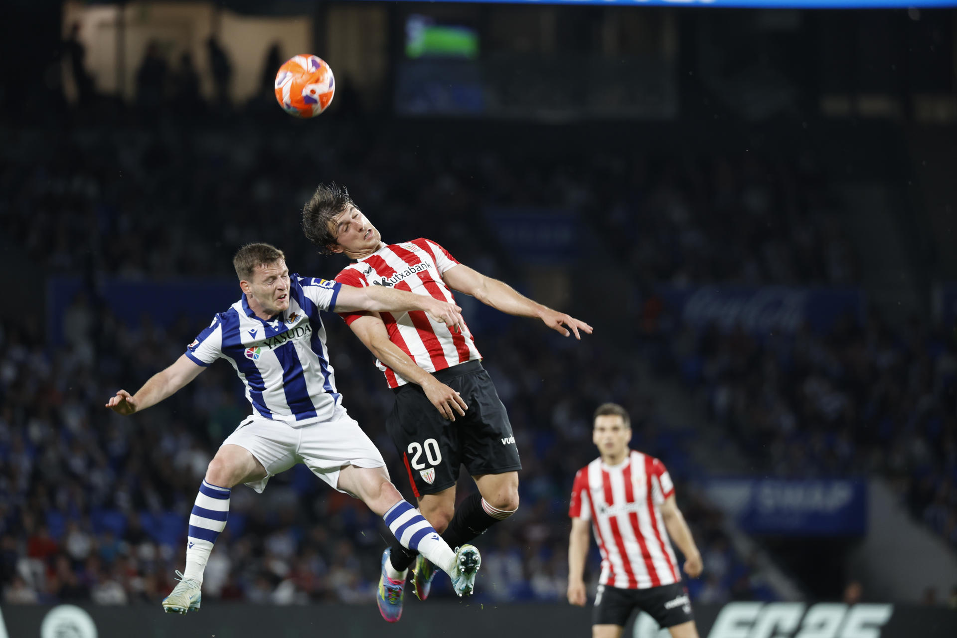 El defensa de la Real Sociedad Sergio Gómez (i) pelea un balón ante el centrocampista del Athletic Unai Gómez, durante el partido de LaLiga EA Sports de fútbol que Real Sociedad y Athletic Club disputaron en el Reale Arena, en San Sebastián. EFE/Juan Herrero