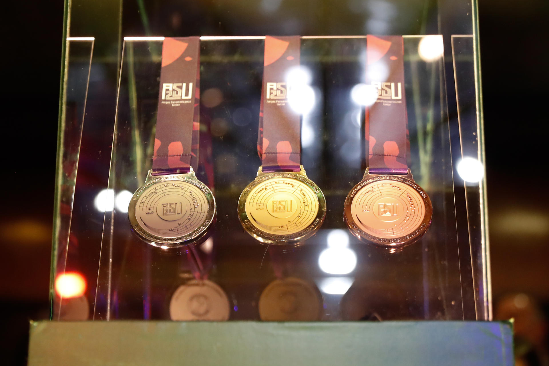 Las medallas de oro (c), plata (i) y bronce de los Juegos Panamericanos Junior ASU2025, durante la presentación oficial en el Teatro Municipal Ignacio A. Pane de Asunción (Paraguay). EFE/ Juan Pablo Pino