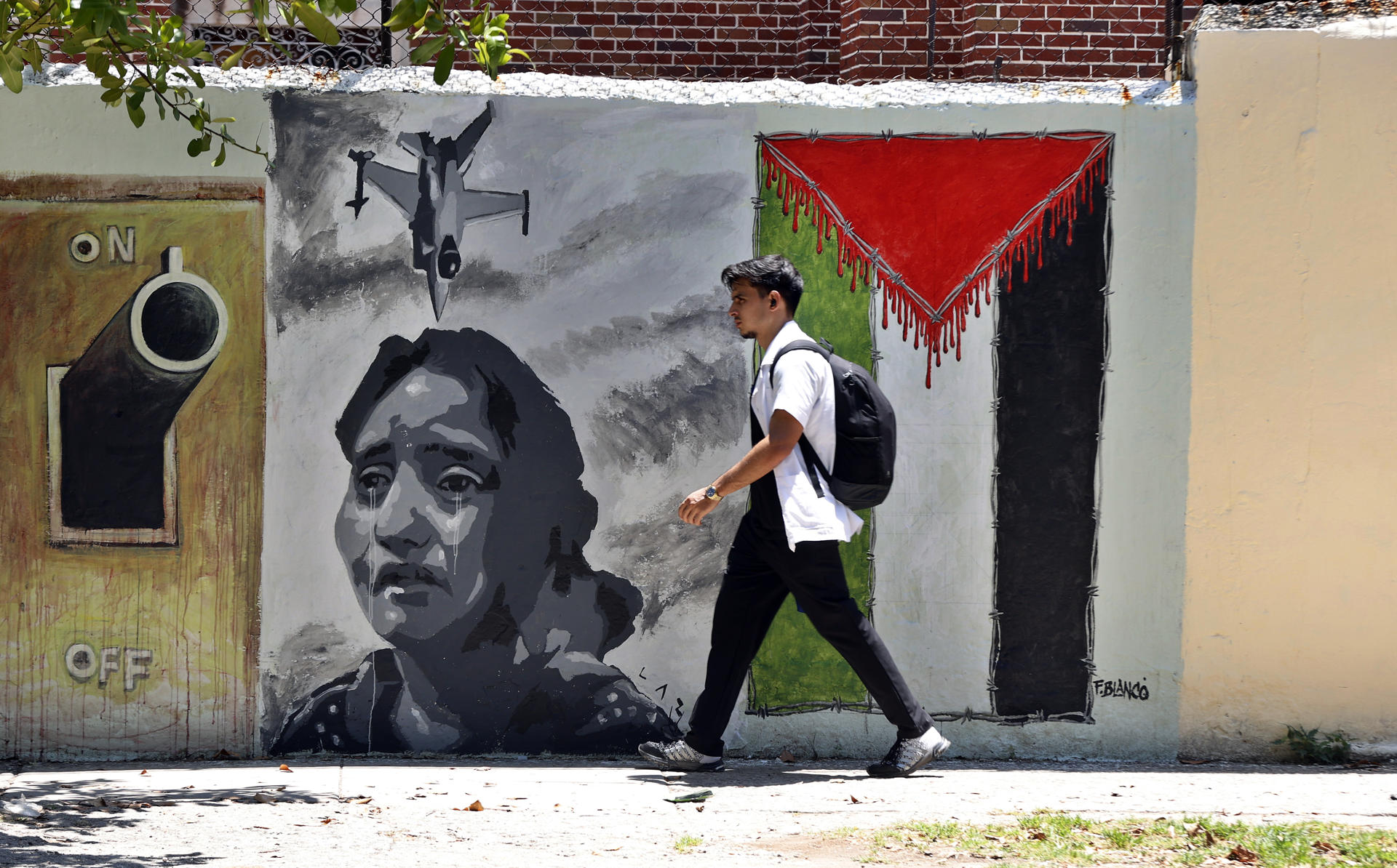 Un hombre fue captado este jueves, 15 de mayo, al caminar frente a un mural alusivo a la causa palestina y en memoria del 77 aniversario del inicio de la Nakba (catástrofe, en árabe), que marcó la expulsión de unos 700.000 palestinos de sus tierras forzados por milicias judías, en La Habana (Cuba). EFE/Ernesto Mastrascusa