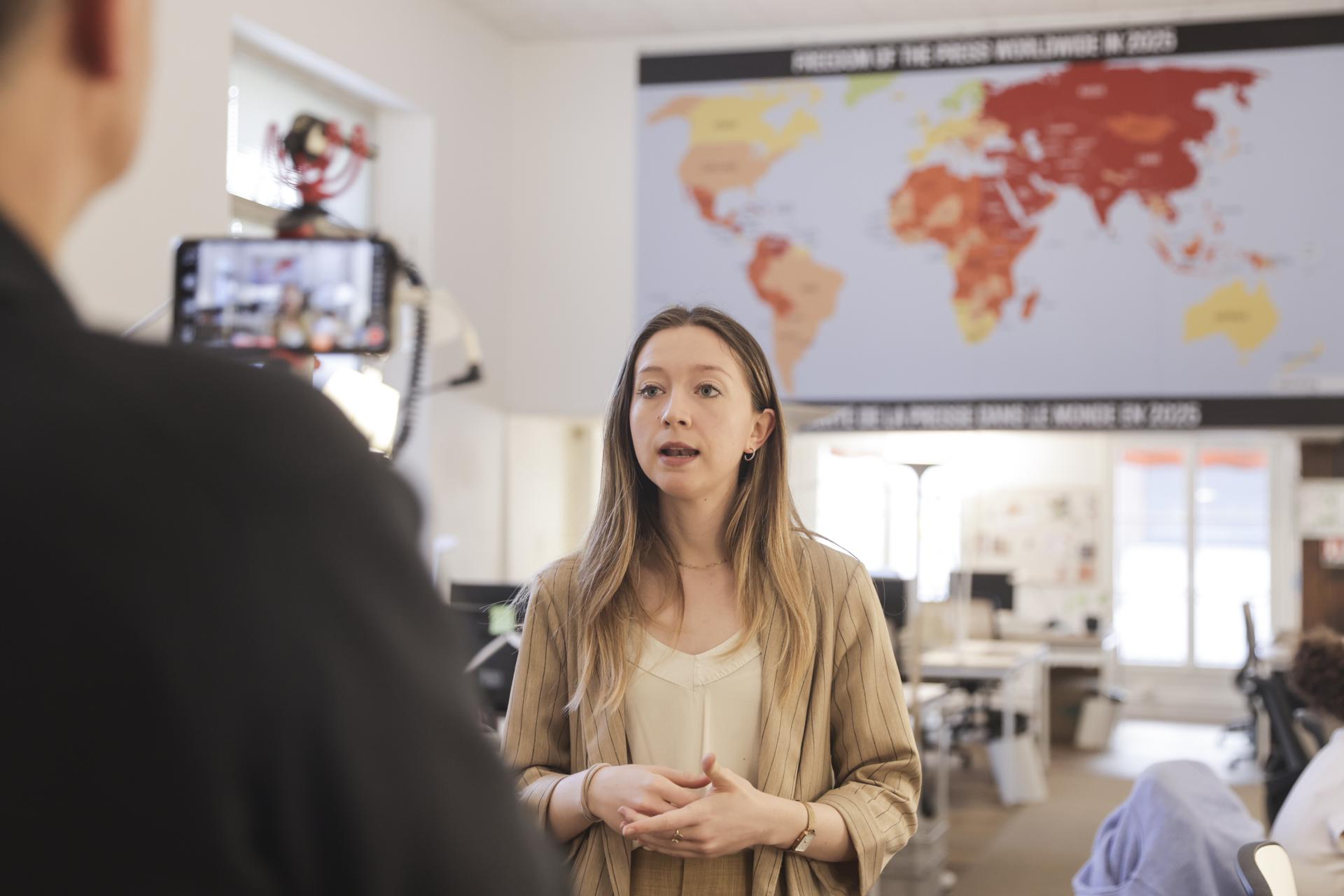 La portavoz de la ONG Reporteros Sin Fronteras, Elena García Viscasillas, habla con un periodista durante la presentación de su Índice Mundial de Libertad de Prensa 2025 en París.- 
EFE/EPA/TERESA SUAREZ
