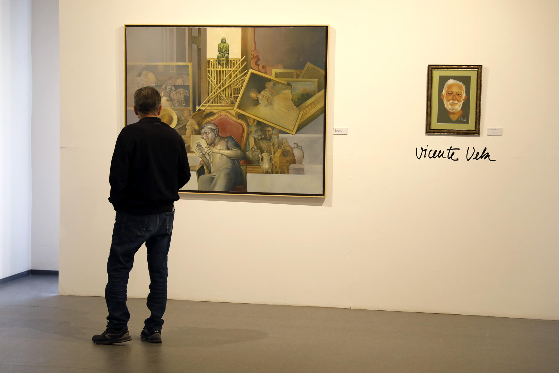 Una persona observa una obra que pertenece a la exposición retrospectiva homenaje a Vicente Vela, el artista que diseñó el primer anagrama de Loewe y que puso durante 40 años su talento al servicio de esta marca, a través de 37 lienzos con los que se recorre su trayectoria artística, este miércoles en Algeciras (Cádiz). EFE/A.Carrasco Ragel.
