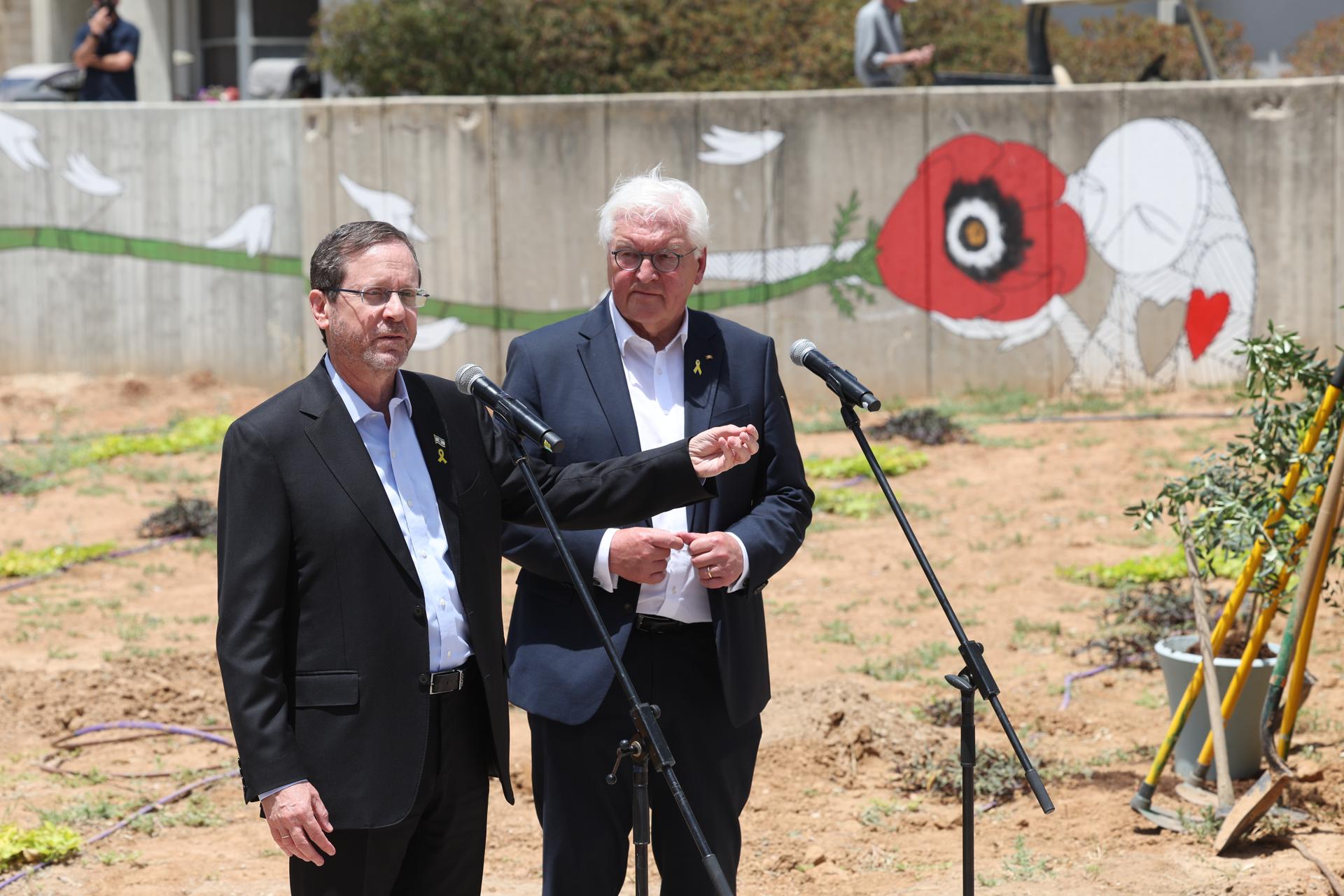 El presidente israelí Isaac Herzog (I) y el presidente alemán Frank-Walter Steinmeier (D) hacen una declaración en el lugar donde solía estar la antigua Galería de Arte Be'eri durante su visita al Kibutz Be'eri, cerca de la frontera con Gaza, sur de Israel, 14 de mayo de 2025. Los dos presidentes asisten a una ceremonia de colocación de la primera piedra en la antigua galería de arte Be'eri que fue destruida durante el ataque de Hamás del 7 de octubre y obtienen una visión general de la nueva galería que se construirá en el futuro en el Kibutz Be'eri. La visita de Steinmeier tiene lugar con motivo del 60 aniversario del establecimiento de relaciones diplomáticas entre Alemania e Israel. (Alemania, Kibutz) EFE/EPA/ABIR SULTAN