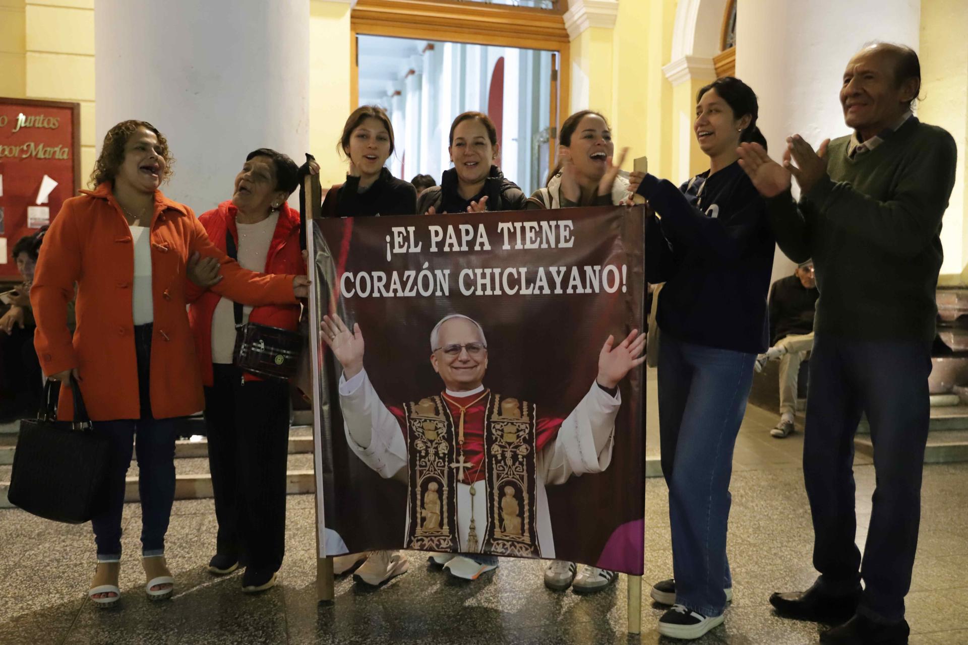 Un grupo de fieles muestra una pancarta del Papa este 8 de mayo de 2025, en la iglesia Santa María Catedral de Chiclayo (Perú). EFE/Ynocente Llontop