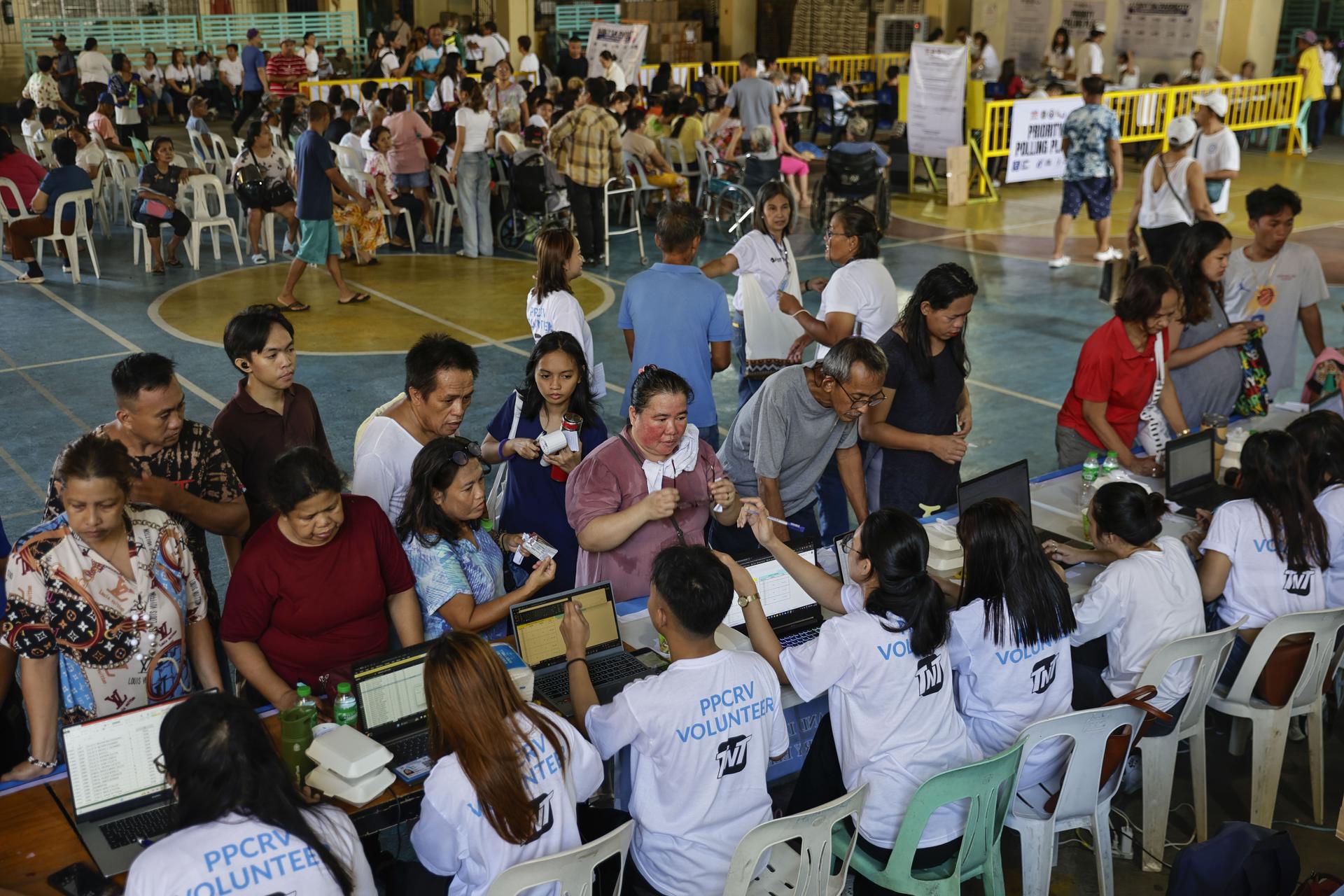 Fotografía de archivo de las elecciones nacionales y locales de mitad de mandato que Filipinas celebró el 12 de mayo de 2025 y que muestra a votantes de Ciudad Quezón, Metro Manila, Filipinas, consultando a voluntarios electorales. EFE/EPA/ROLEX DELA PENAEFE/EPA/ROLEX DELA PENA
