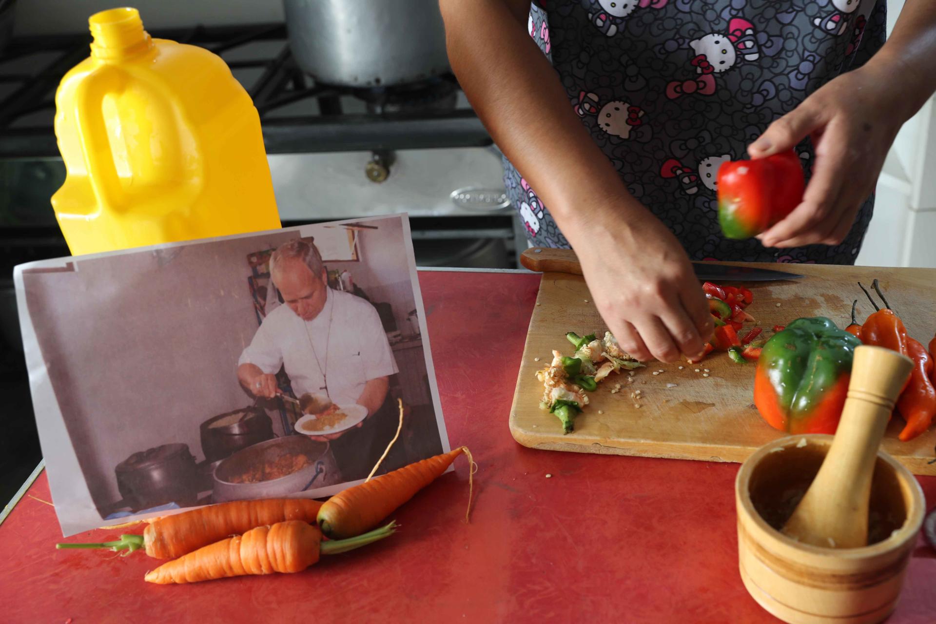 Gaby Ruzasto prepara alimentos para repartir a personas sin recursos en Chiclayo (Perú), con la imagen del papa León XIV sirviéndose concentrado, un plato típico de comida casera peruana. EFE/ Paolo Aguilar