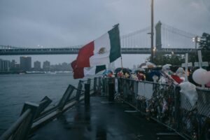 Banderas de México ondean al viento durante una vigilia en memoria de dos jóvenes cadetes de la Armada que fallecieron cuando el buque Cuauhtémoc de la Armada de México impactó el Puente de Brooklyn el 17 de mayo en Nueva York, EE. UU., el 21 de mayo de 2025. EFE/EPA/OLGA FEDOROVA