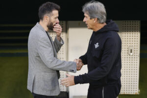 El entrenador del Betis, Manuel Pellegrini (d), saluda al del Valencia, Carlos Corberán (i), antes del partido de la última jornada de LaLiga de fútbol que Real Betis y Valencia CF disputan este viernes en el estadio Benito Villamarín, en Sevilla. EFE/Julio Muñoz