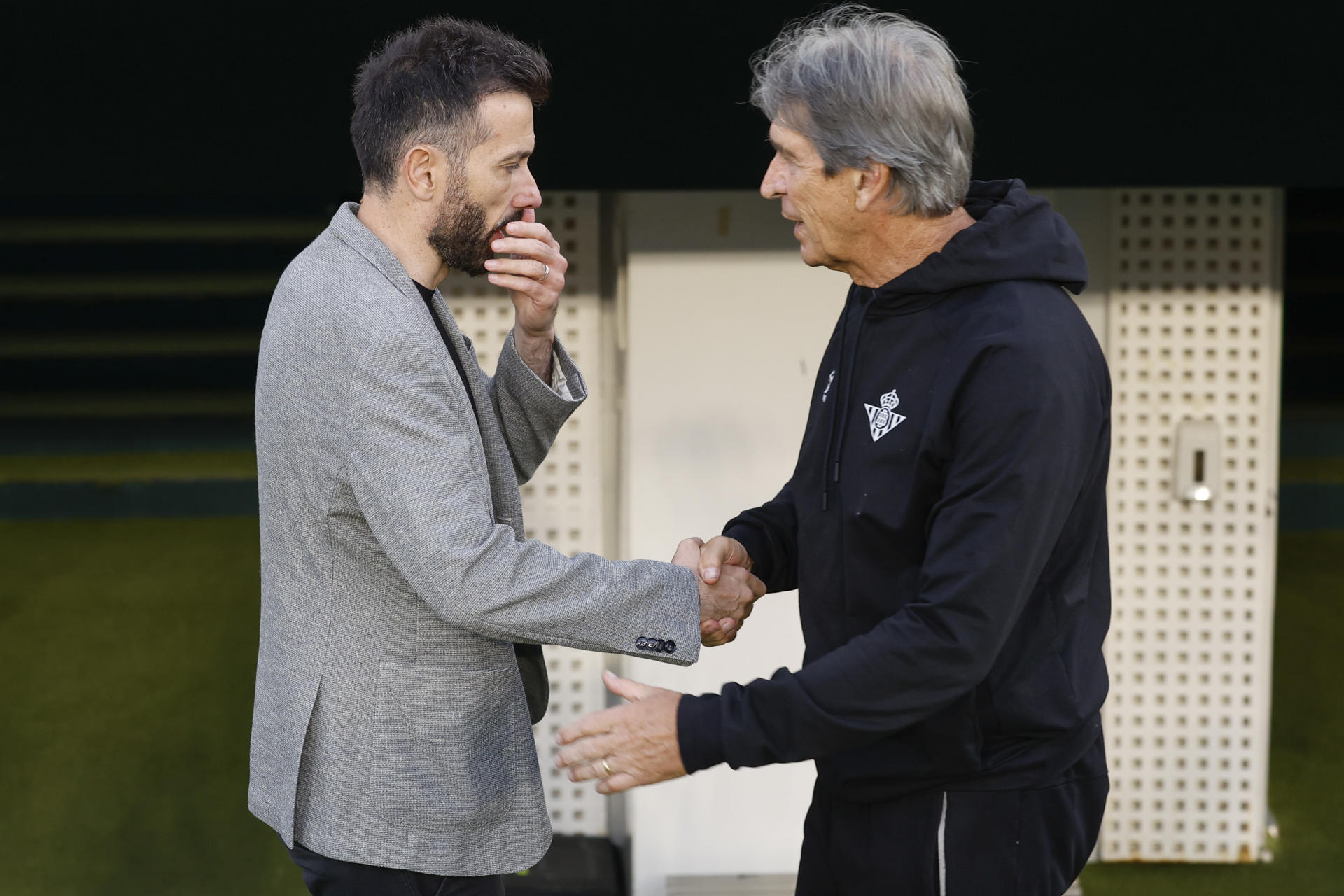 El entrenador del Betis, Manuel Pellegrini (d), saluda al del Valencia, Carlos Corberán (i), antes del partido de la última jornada de LaLiga de fútbol que Real Betis y Valencia CF disputan este viernes en el estadio Benito Villamarín, en Sevilla. EFE/Julio Muñoz