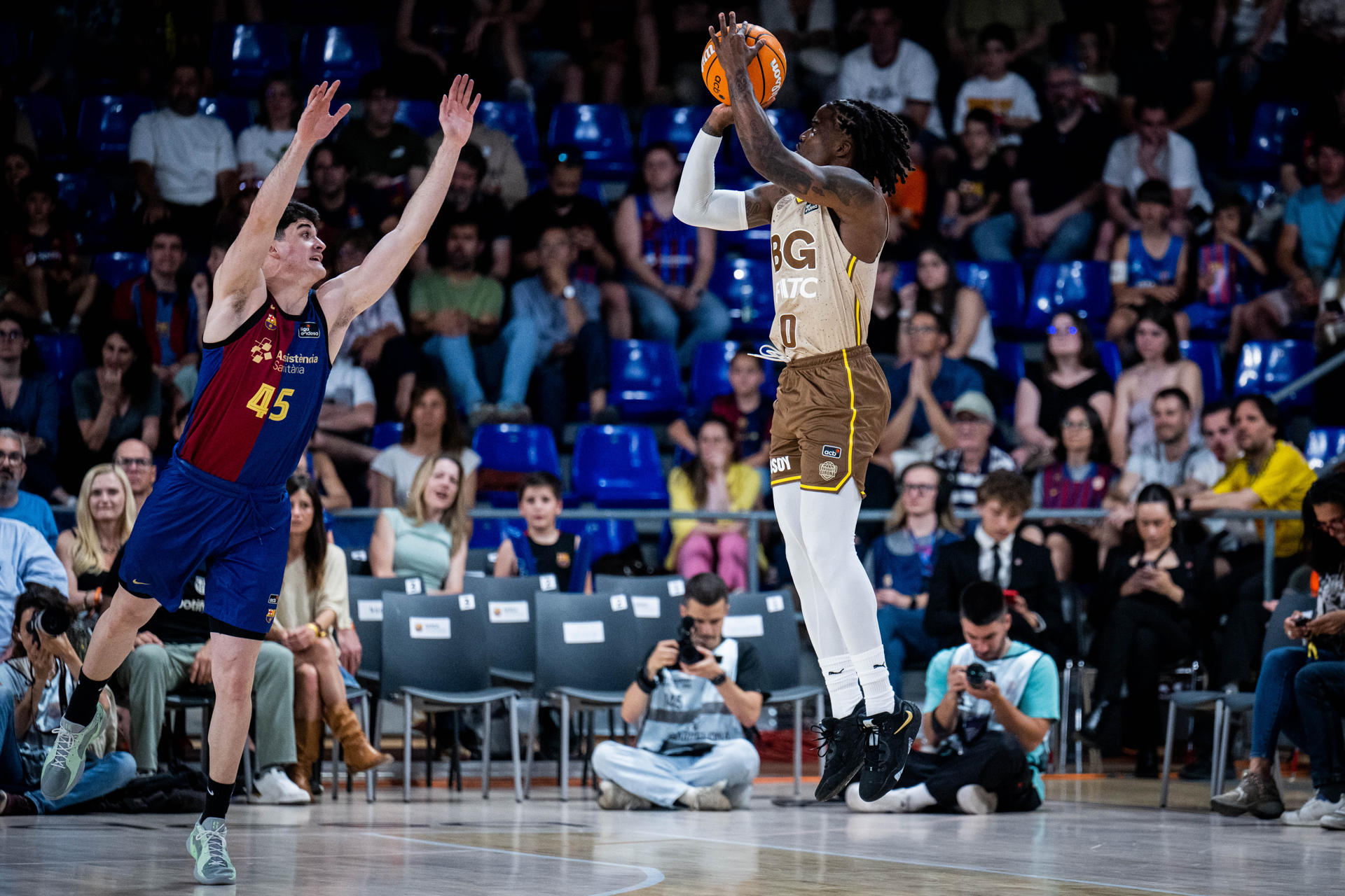 El base nigeriano del Girona Ike Iroegbu (d) lanza a canasta este domingo durante un partido de la Liga Endesa de baloncesto, en el Palau Blaugrana de Barcelona. EFE/ Acb Photo / Víctor Salgado