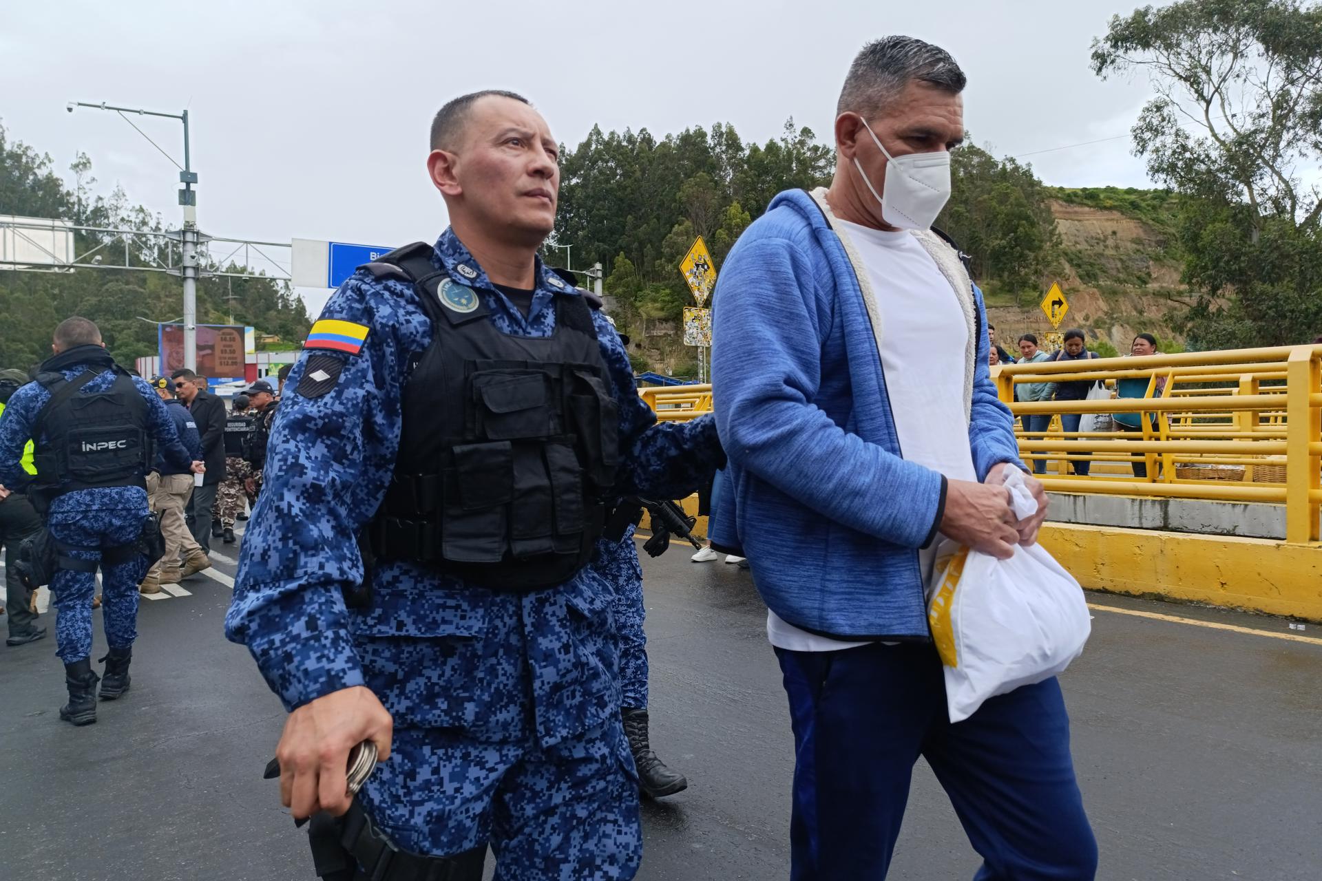 Un integrante del Instituto Nacional Penitenciario y Carcelario custodia a un hombre colombiano este miércoles, en Rumichaca (Ecuador). EFE/ Xavier Montalvo