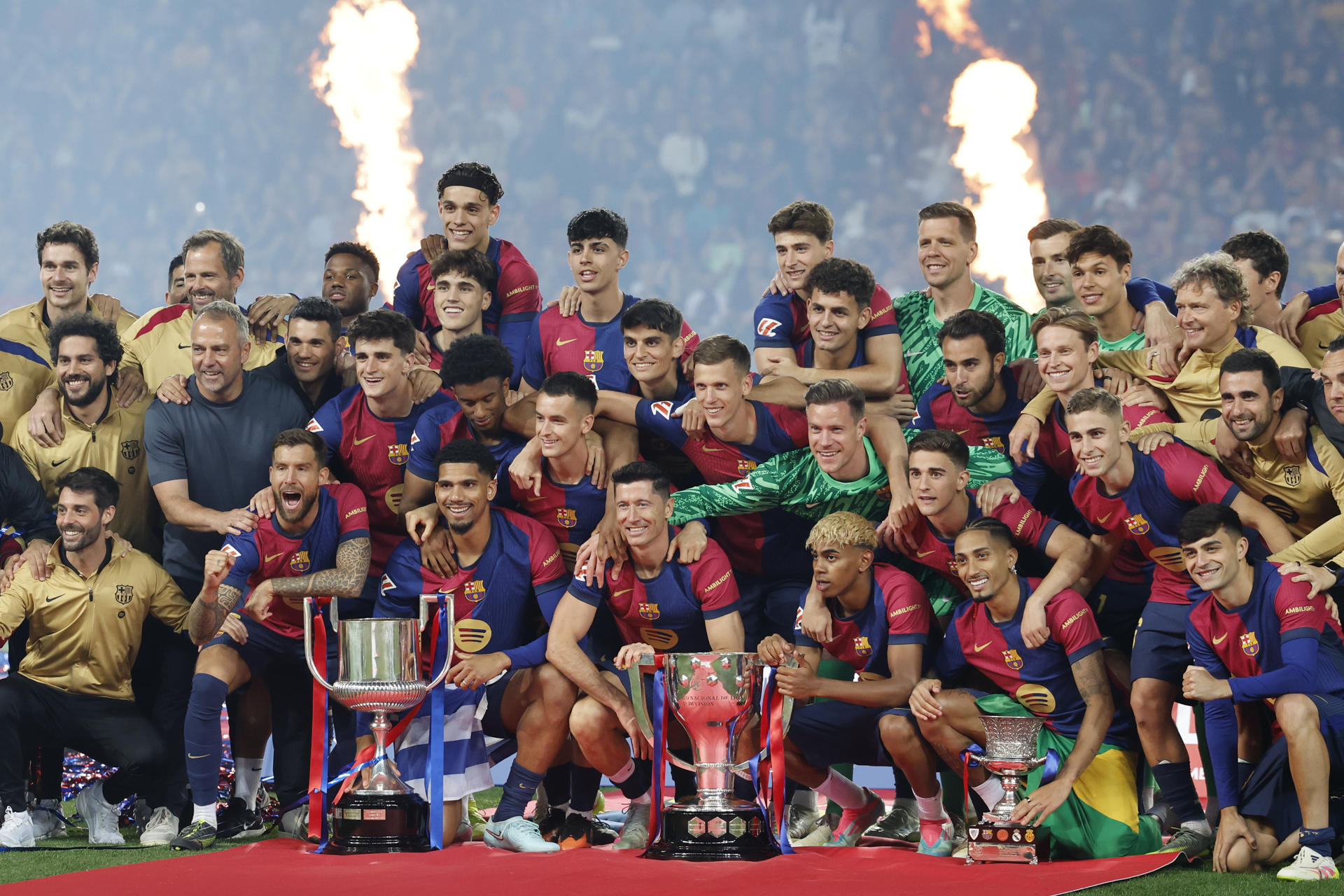 Los jugadores del Barcelona celebran el título de Liga, de Copa y se Supercopa al final del encuentro de la jornada 37 de LaLiga entre FC Barcelona y Villarreal CF disputado este domingo en el Estadio Olímpico de Montjuic. EFE/Toni Albir
