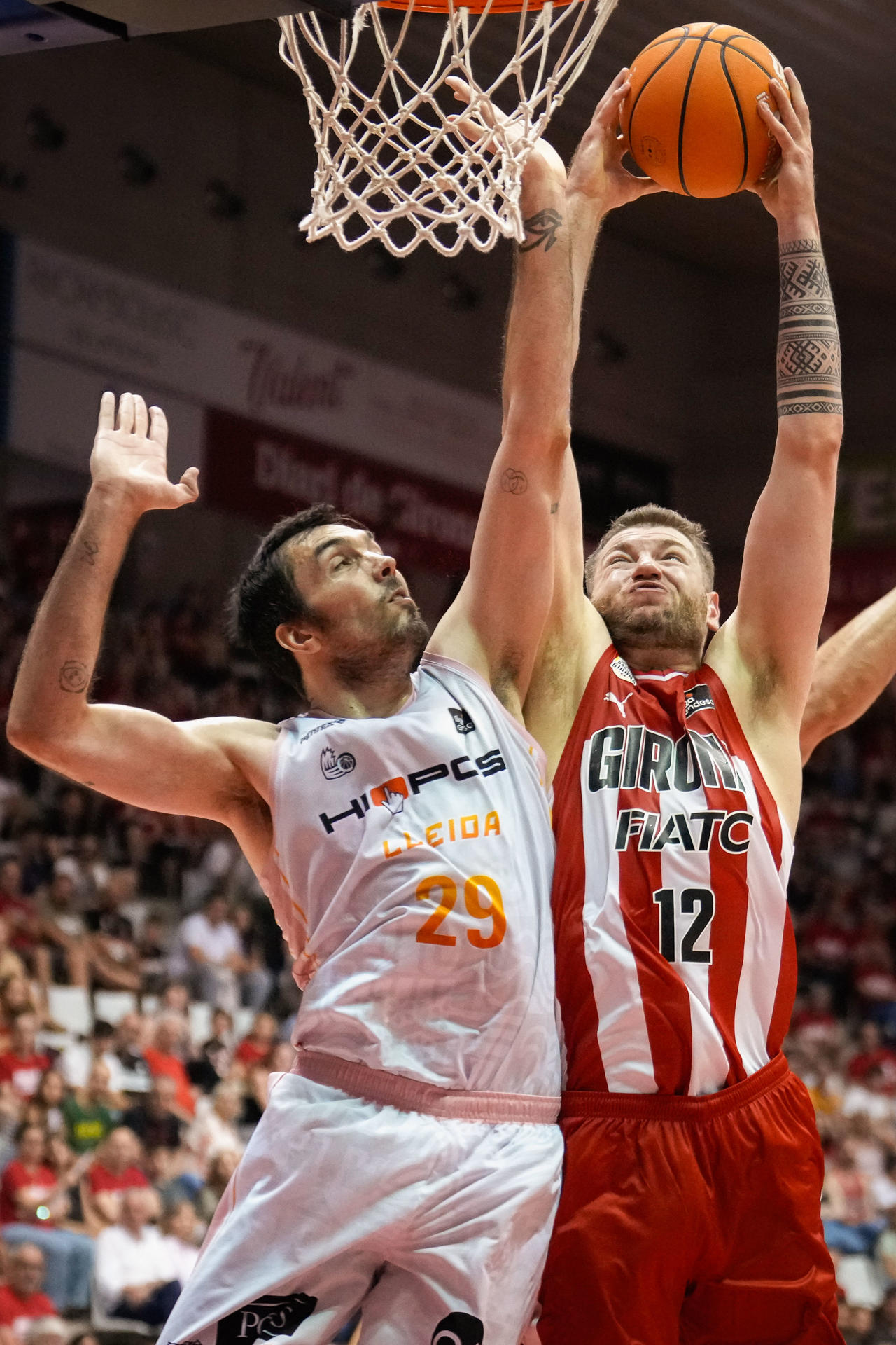 El alero del Lleida Pierre Oriola defiende al pívot lituano del Basquet Girona Martinas Geben, durante el partido de la Liga Endesa entre el Basquet Girona y el Hiopos Lleida celebrado este jueves, en el pabellón de Fontajau en Girona. EFE/ David Borrat