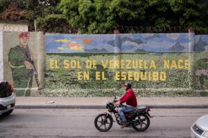 Fotografía de archivo de un hombre que conduce una moto frente a un mural que dice "El sol de Venezuela nace por el esequibo". EFE/ Rayner Peña R.