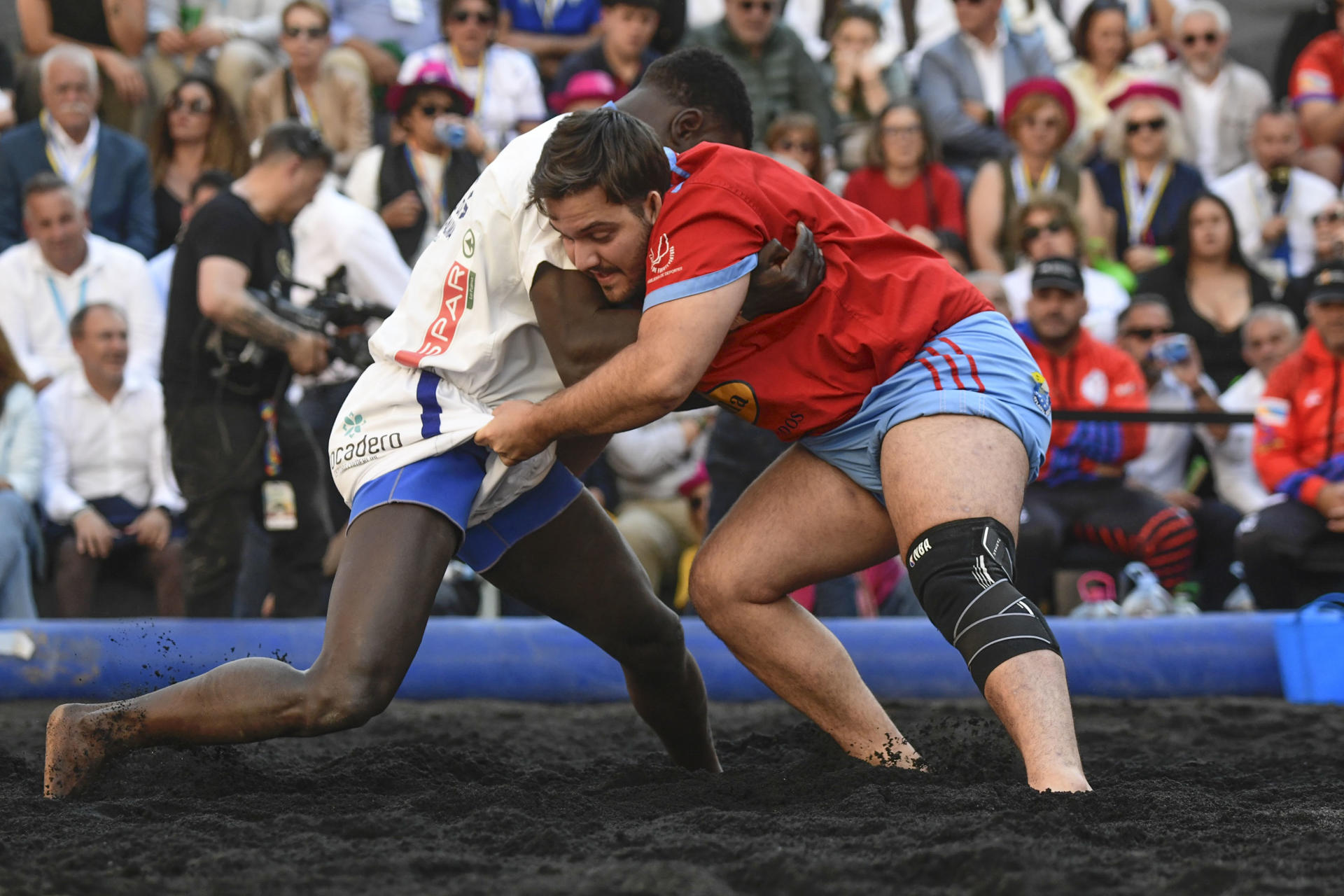 - Uno de los combates de la primera competición oficial de lucha canaria que tiene lugar fuera de las islas, una luchada entre los clubes Saladar de Jandía (Fuerteventura) y Candelaria de Mirca (La Palma) sobre un terrero habilitado para la ocasión en la plaza de Callao de Madrid con ceniza del volcán Tajogaite. EFE/ Victor Lerena