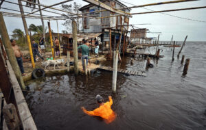 Un pescador nada en el agua tras el paso del huracán Rafael, en Playa Majana, en la provincia de Artemisa (Cuba), en una imagen de archivo. EFE/ Ernesto Mastrascusa