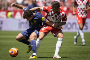 El delantero del Atllético de Madrid Julián Álvarez (I) y el centrocampista brasileño del Girona Arthur Melo, durante el partido de Liga que Girona y Atlético de Madrid disputaron en el estadio municial de Moltilivi. EFE/David Borrat