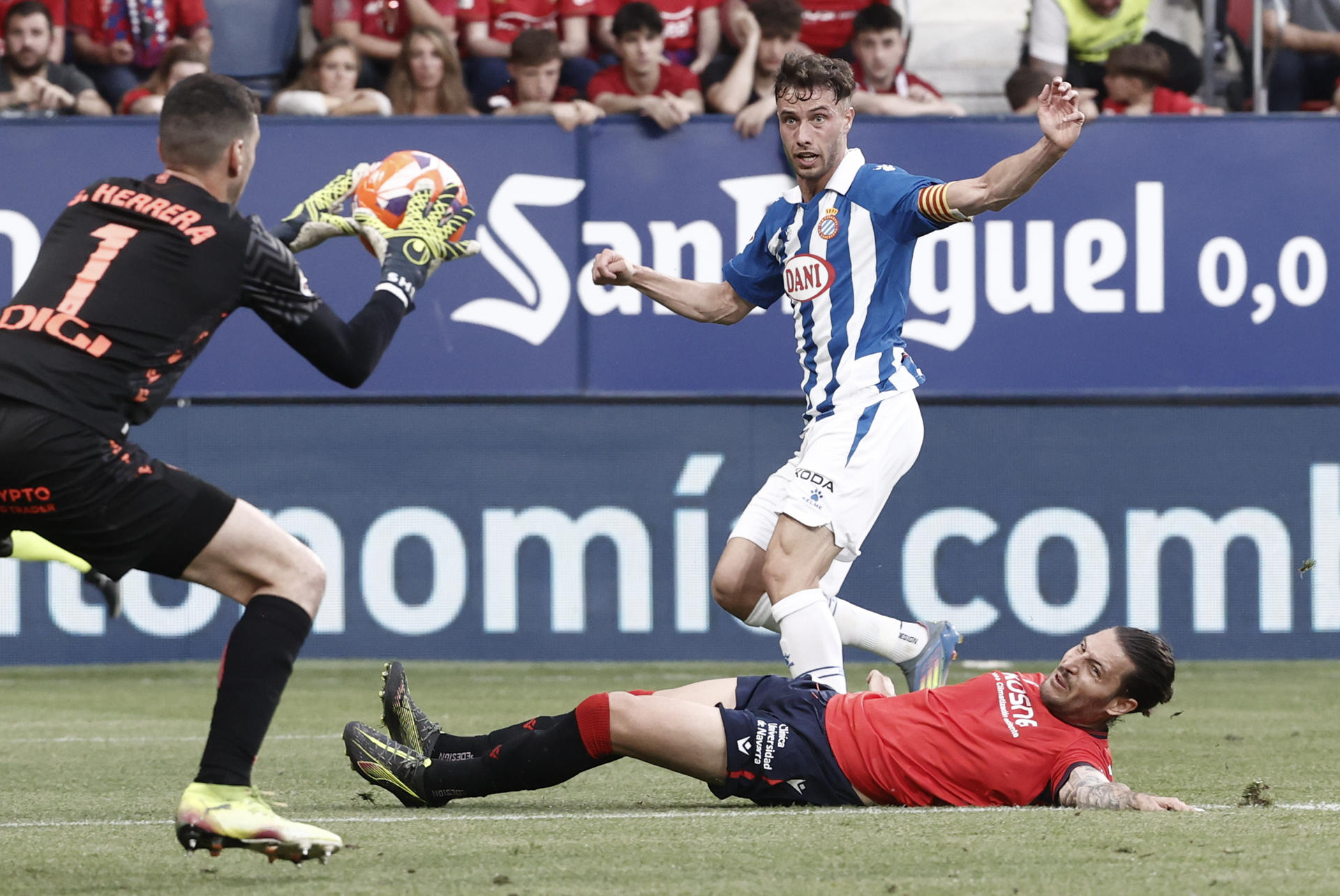 El portero del Osasuna Sergio Hererra (i) atrapa un lanzamiento del delantero del Espanyol Javi Puedo (detrás) durante el partido de LaLiga entre el Osasuna y el Espanyol en el estadio de El Sadar, en Pamplona. EFE/ Jesús Diges