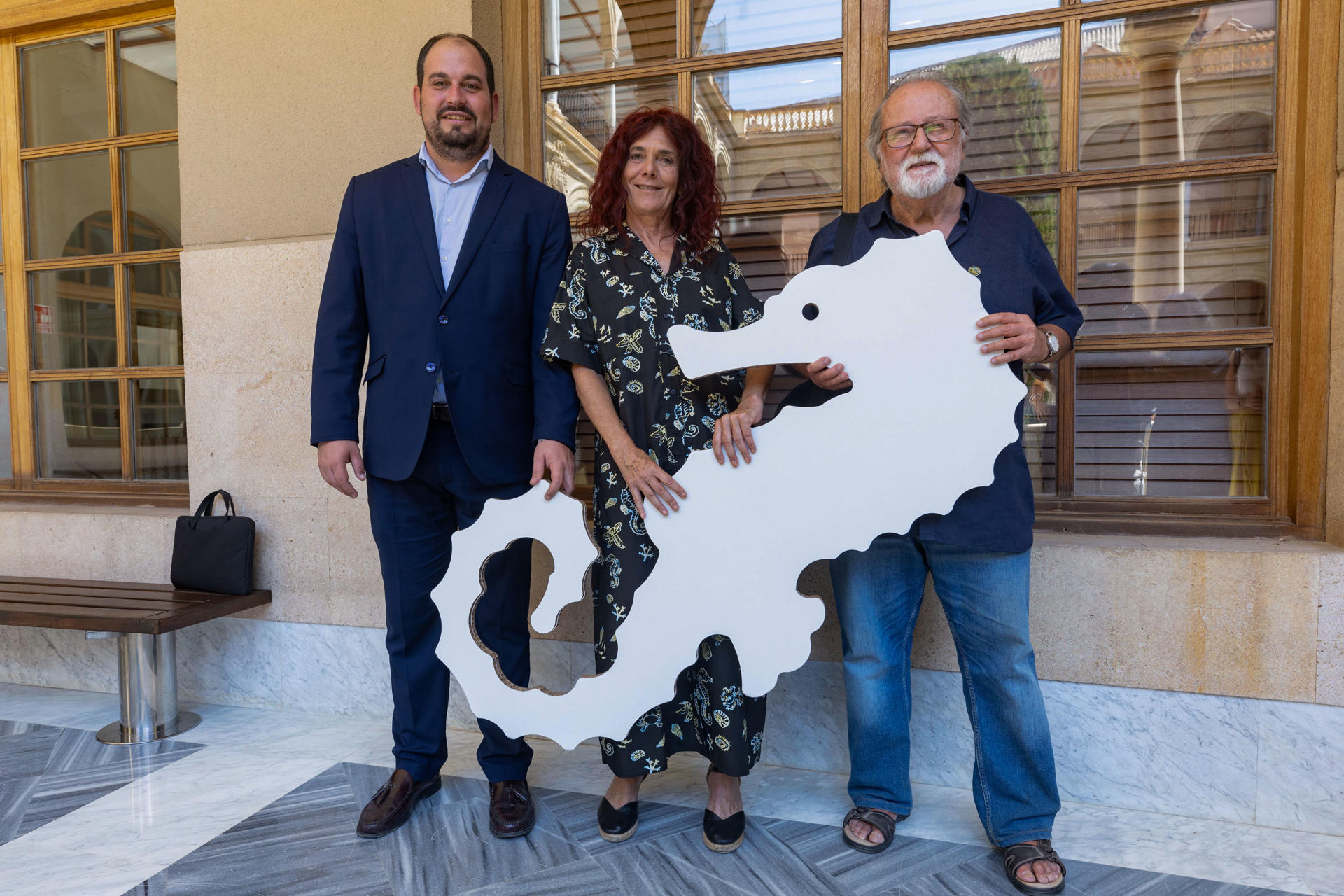 La profesora de Filosofía del Derecho y promotora de la ILP del Mar Menor, Teresa Vicente (c); el catedrático de Ecología Miguel Ángel Esteve (d) y el alcalde de Los Alcázares, Mario Pérez Cervera,  posan con un caballito de mar tras ser nombrados tutores del mar Menor, este jueves, en la Facultad de derecho de la Universidad de Murcia. EFE/Marcial Guillén