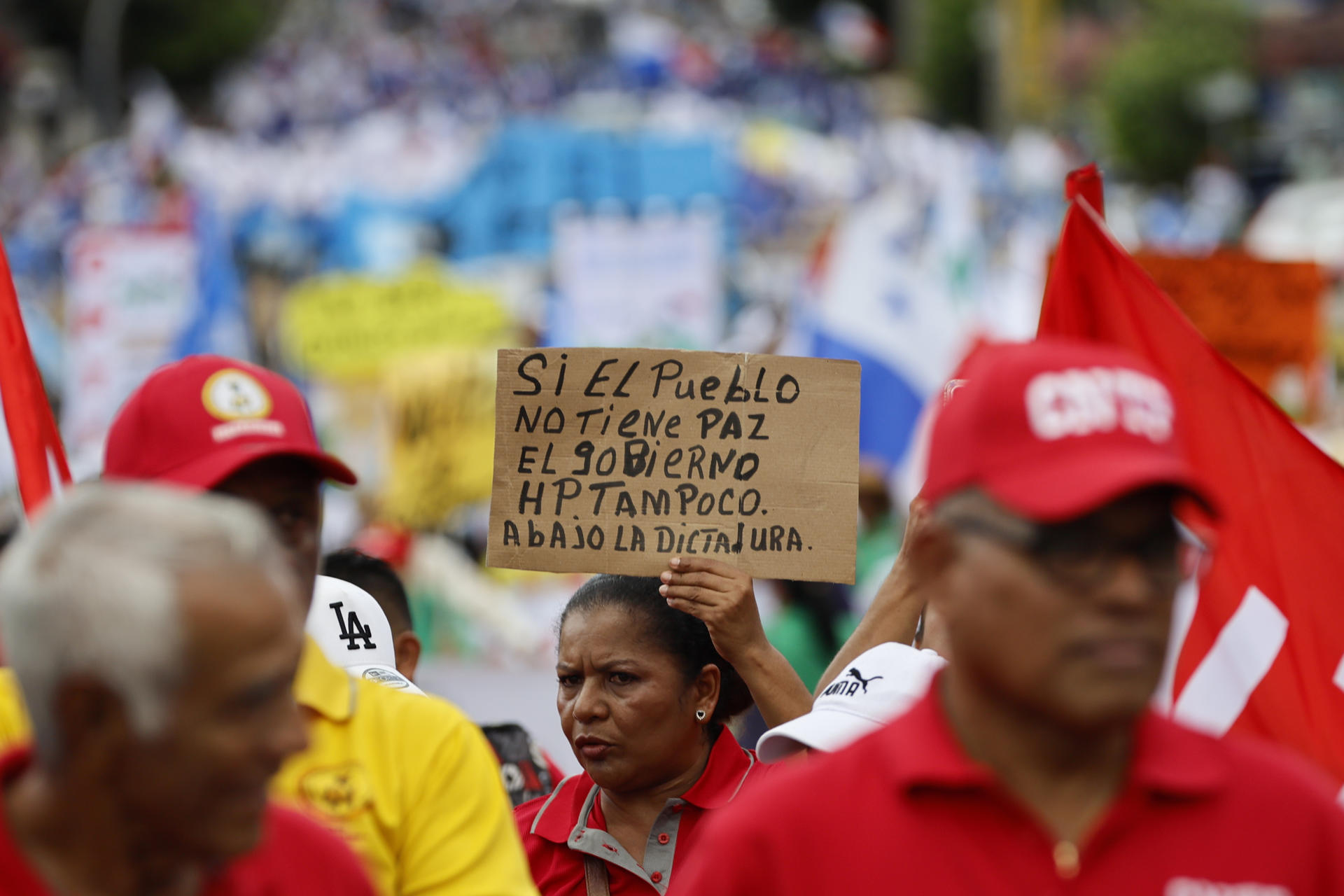Una mujer sostiene un cartel durante la manifestación del Primero de Mayo este jueves, en Ciudad de Panamá (Panamá). EFE/ Bienvenido Velasco