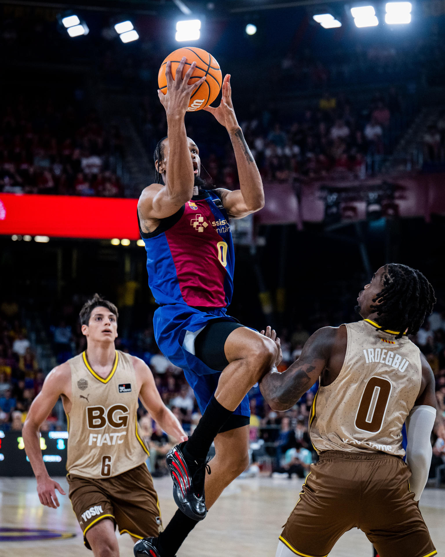 El base estadounidense del Barça Kevin Punter (c) entra a canasta ante Ike Iroegbu del Girona este domingo durante un partido de la Liga Endesa de baloncesto, en el Palau Blaugrana de Barcelona. EFE/ Acb Photo / Víctor Salgado