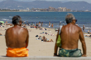 Dos personas contemplan la afluencia en la playa de la Malvarrosa (Valencia) durante la mañana del martes. EFE/Ana Escobar